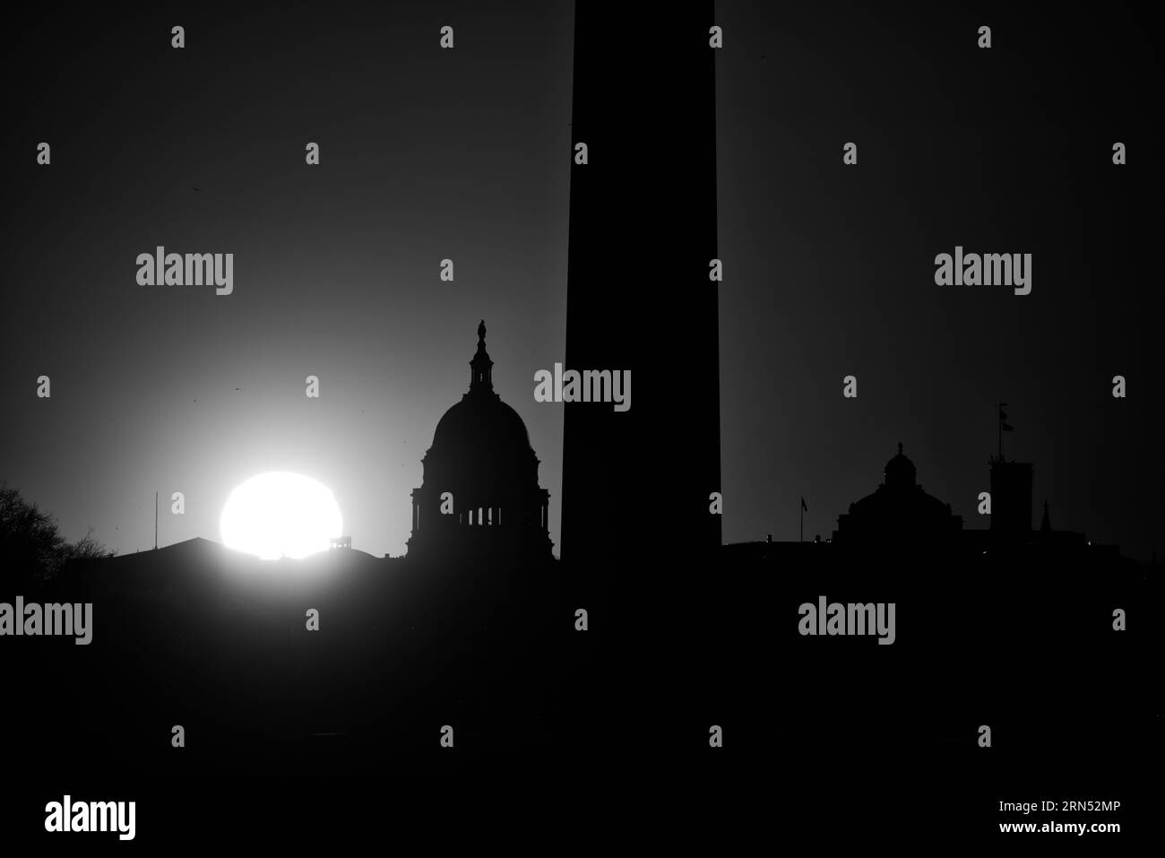 Silhouette du dôme du Capitole des États-Unis, Washington DC — Photo en noir et blanc | Dôme du Capitole des États-Unis au coucher du soleil, Washington, D.C. Photographie en noir et blanc montrant la silhouette du dôme et d'autres bâtiments devant le soleil éclatant. Banque D'Images