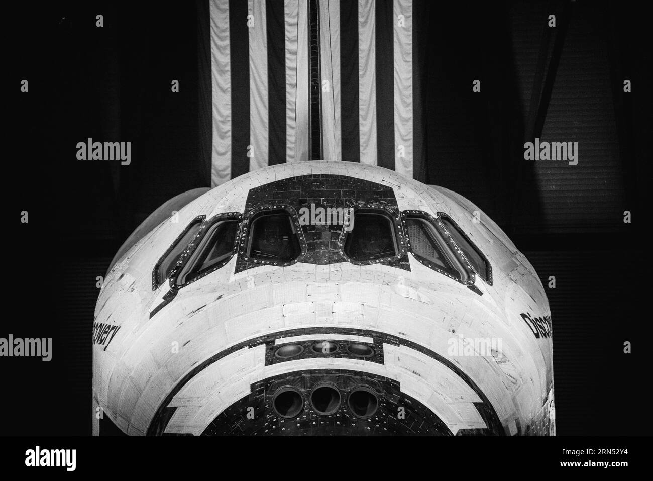 Navette spatiale Discovery, Steven F. Udvar-Hazy Center, Chantilly. Photographie en noir et blanc montrant le nez de la navette et le drapeau américain en arrière-plan. Banque D'Images