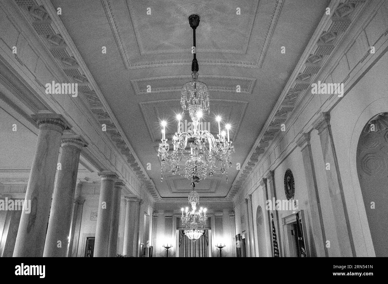 Lustres et colonnes en cristal, Maison Blanche, Washington DC — Photo noir et blanc | Lustres et colonnes en cristal, Maison Blanche, Washington, D.C. Photographie noir et blanc regardant vers le plafond orné, les lustres en cristal et les colonnes néoclassiques. Banque D'Images