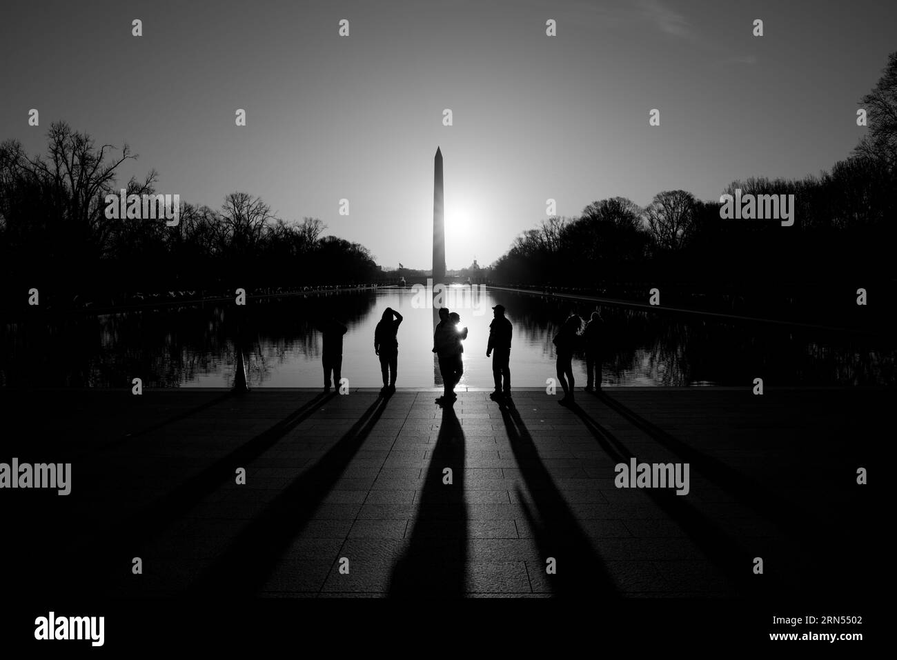 Washington Monument, National Mall, Washington DC — Photo noir et blanc | Washington Monument au lever du soleil, National Mall, Washington, D.C. Photographie noir et blanc montrant l'obélisque reflété dans le bassin réfléchissant avec des silhouettes au premier plan. Banque D'Images