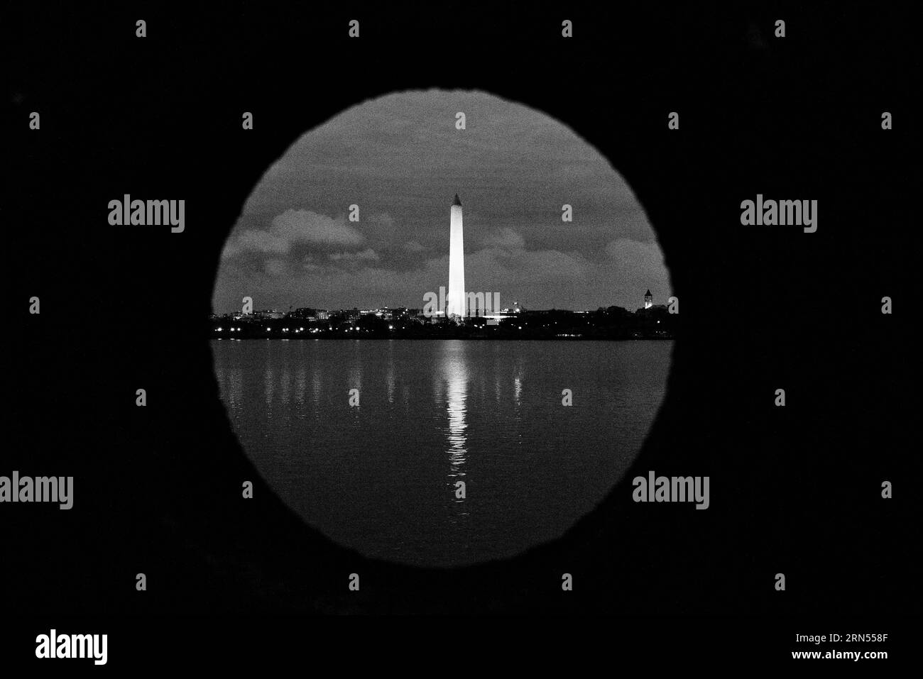Washington Monument, Washington DC — Photo noir et blanc | Washington Monument, Washington, D.C. Photographie noir et blanc montrant le monument à travers l'eau, encadré par un avant-plan sombre et circulaire. Banque D'Images