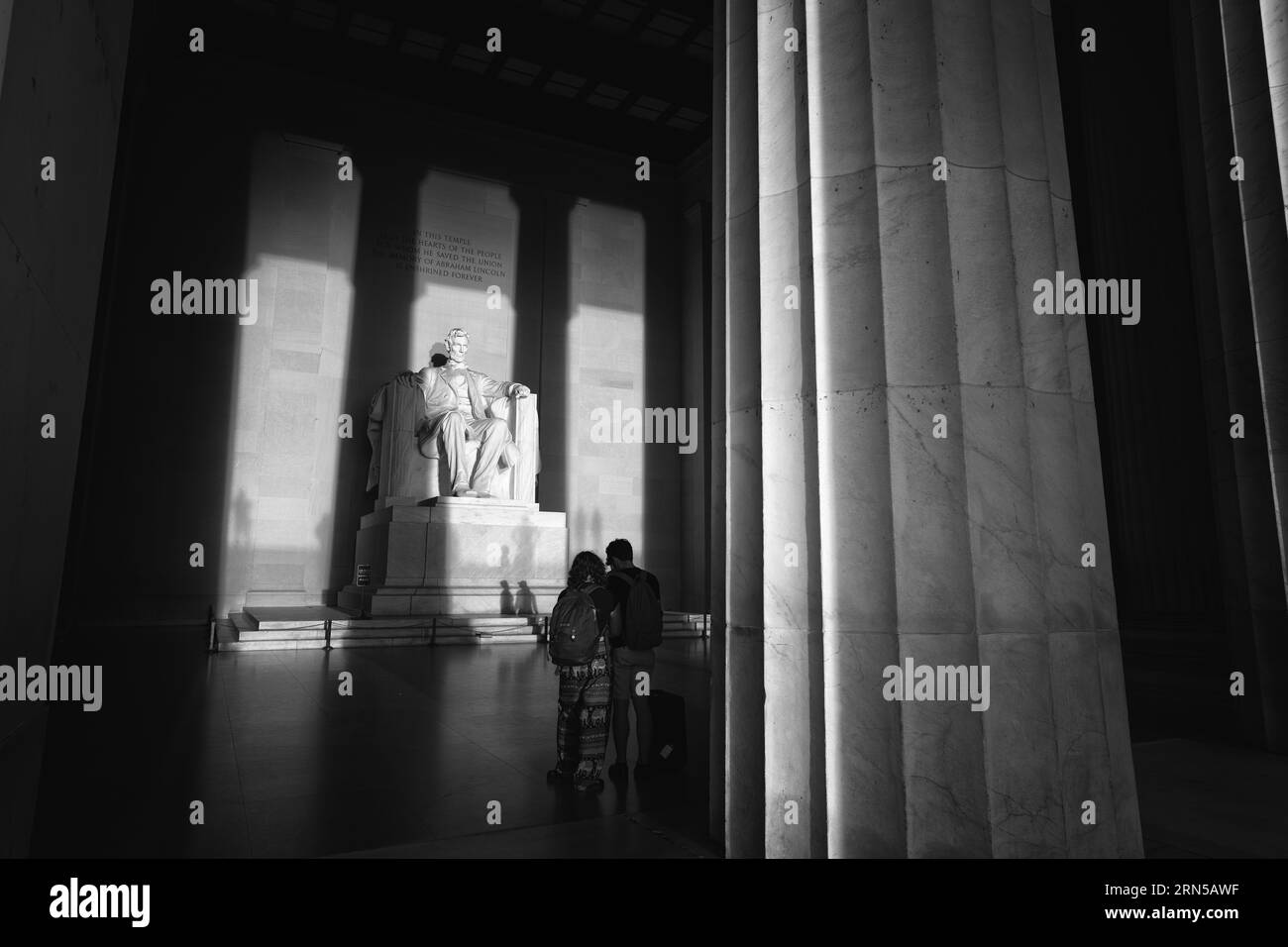 Statue de Lincoln, Lincoln Memorial, Washington DC — Photo noir et blanc | Statue de Lincoln, Lincoln Memorial, Washington, D.C. Photographie noir et blanc montrant la statue et deux visiteurs encadrés par les colonnes du mémorial. Banque D'Images