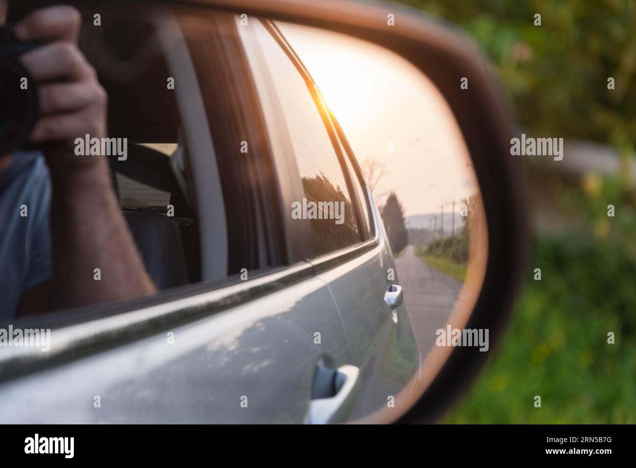 Photo de voyage de la perspective d'aventure de conduite de voiture au rétroviseur de voiture regardant le soleil couchant Banque D'Images