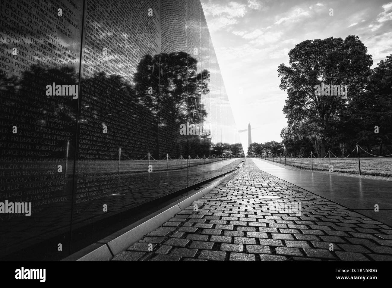Mur commémoratif des vétérans du Vietnam, National Mall, Washington, D.C. photographie en noir et blanc montrant la surface réfléchissante du mur et le monument de Washington au loin. Banque D'Images