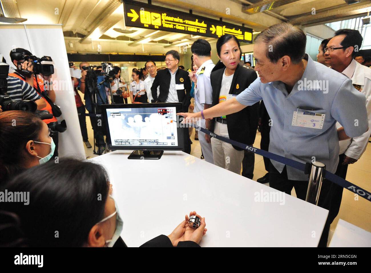 (150621) -- BANGKOK, le 21 juin 2015 -- le ministre thaïlandais de la Santé publique Rajata Rajatanavin (à droite, devant) pointe le doigt sur un thermoscan vérifiant la température corporelle des personnes à l'aéroport Suvarnabhumi de Bangkok, Thaïlande, le 21 juin 2015. Le ministère de la Santé publique de Thaïlande a confirmé jeudi le premier cas de syndrome respiratoire du Moyen-Orient (mers). Les citoyens et les voyageurs ont commencé à adopter des méthodes préventives telles que le port de masques de protection faciaux à Bangkok. Le Département de contrôle des maladies dit que le patient omanais de 75 ans infecté par Mers est sous soins d'isolement à la Bamrasnaradura Infectious Banque D'Images