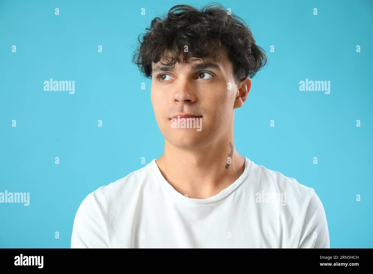 Portrait de beau jeune homme sur fond bleu Banque D'Images