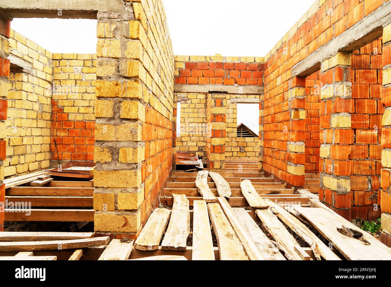 Construction inachevée d'un nouvel immeuble d'appartements. mur de maison en brique rouge en construction. Banque D'Images