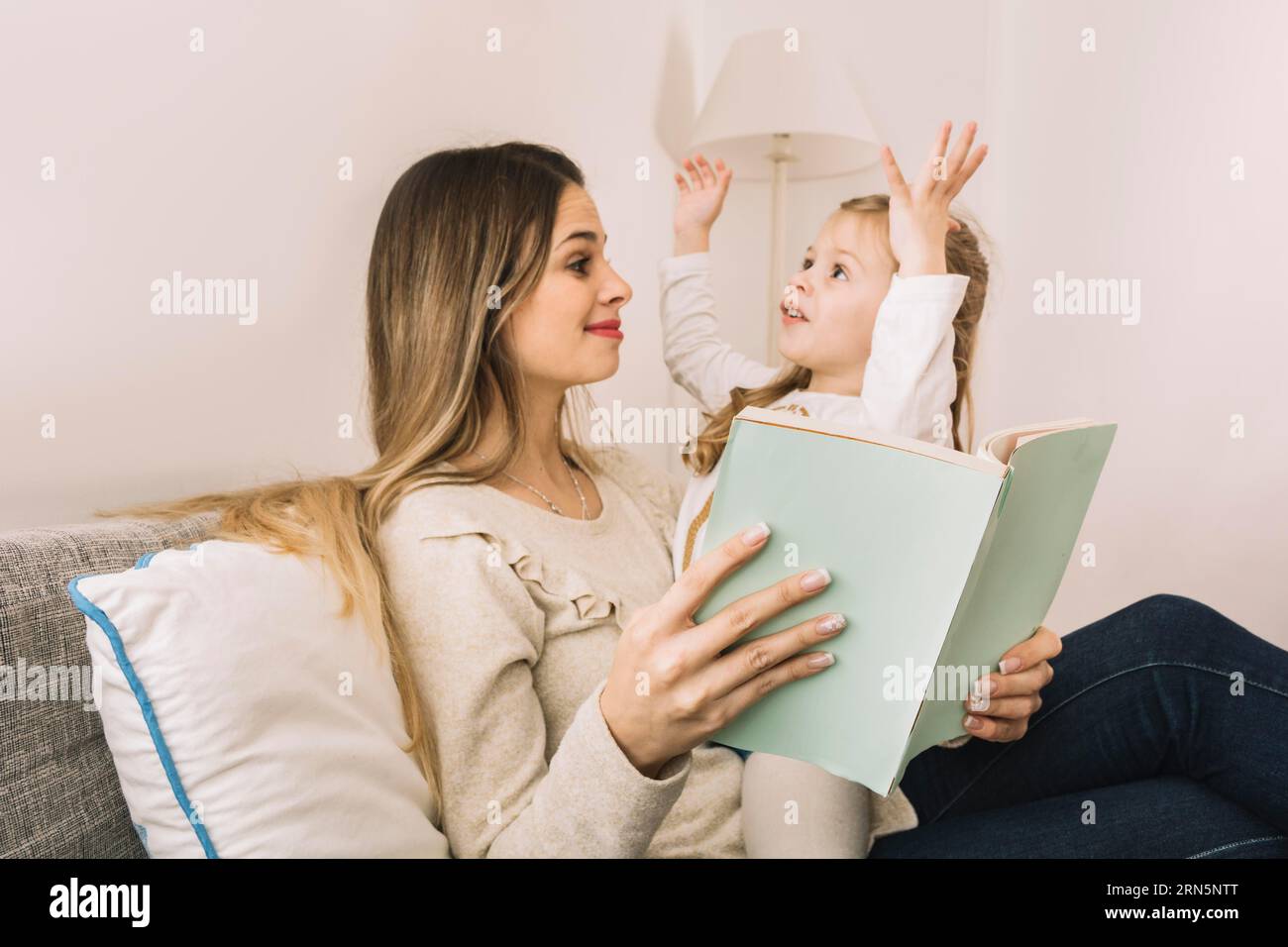 Fille racontant l'histoire maman tout en lisant le livre Banque D'Images