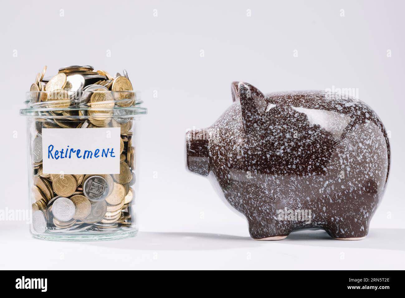 Piggybank près de la retraite récipient en verre pièces pleines Banque D'Images