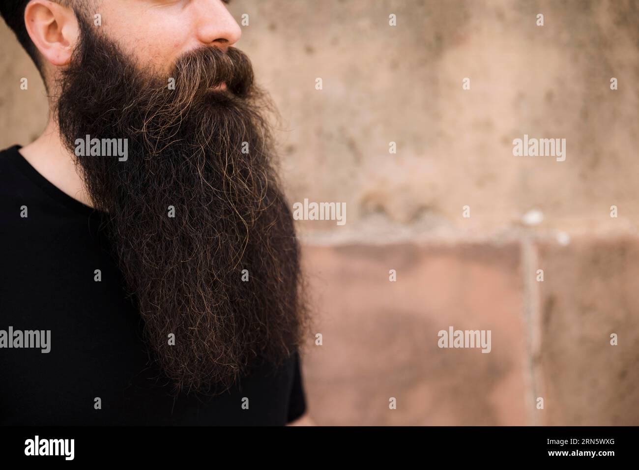 Gros plan jeune homme barbu contre le mur Banque D'Images