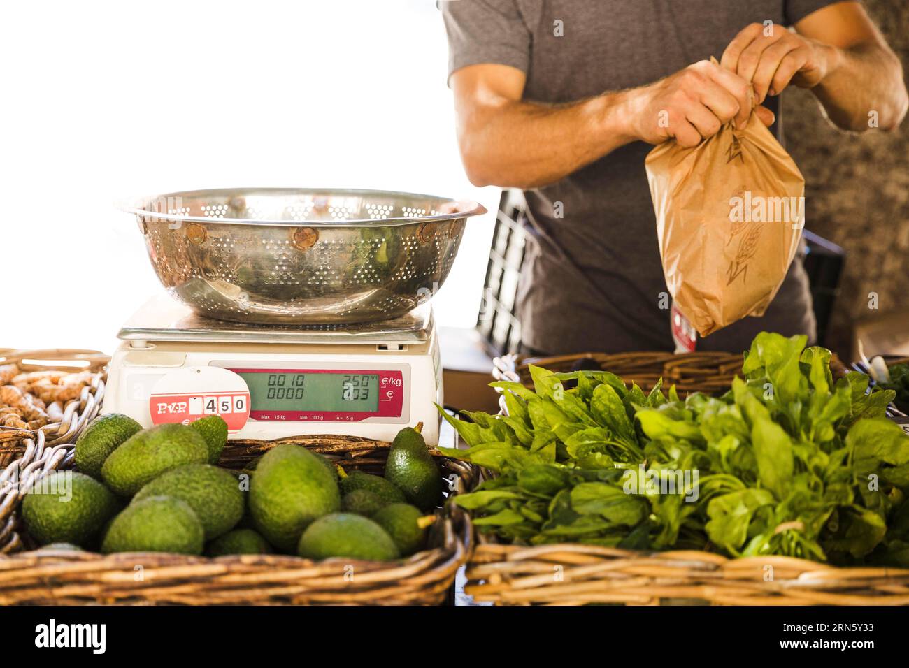 Vendeur de légumes masculin emballant le marché des clients de légumes Banque D'Images