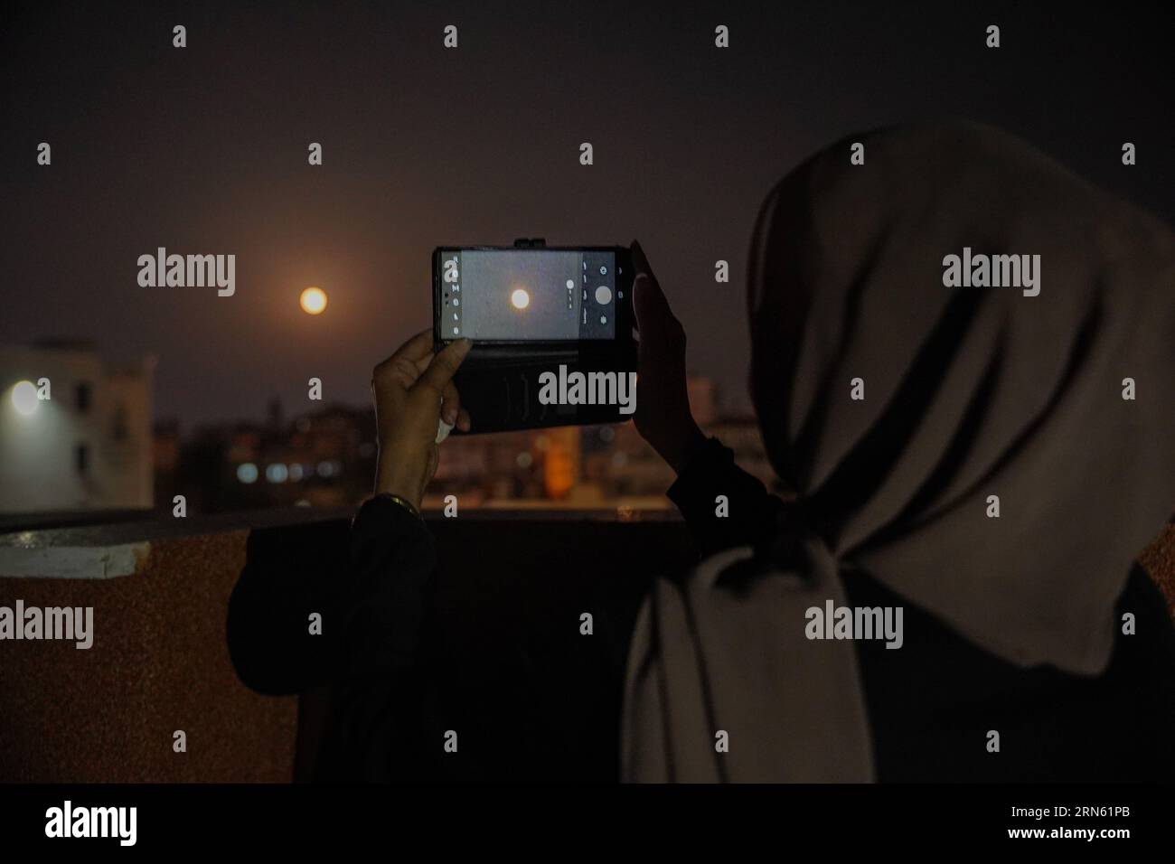 Gaza, Gaza, Palestine. 31 août 2023. Une jeune femme palestinienne prend des photos avec son téléphone de la superlune (crédit image : © Saher Alghorra/ZUMA Press Wire) À USAGE ÉDITORIAL SEULEMENT! Non destiné à UN USAGE commercial ! Banque D'Images
