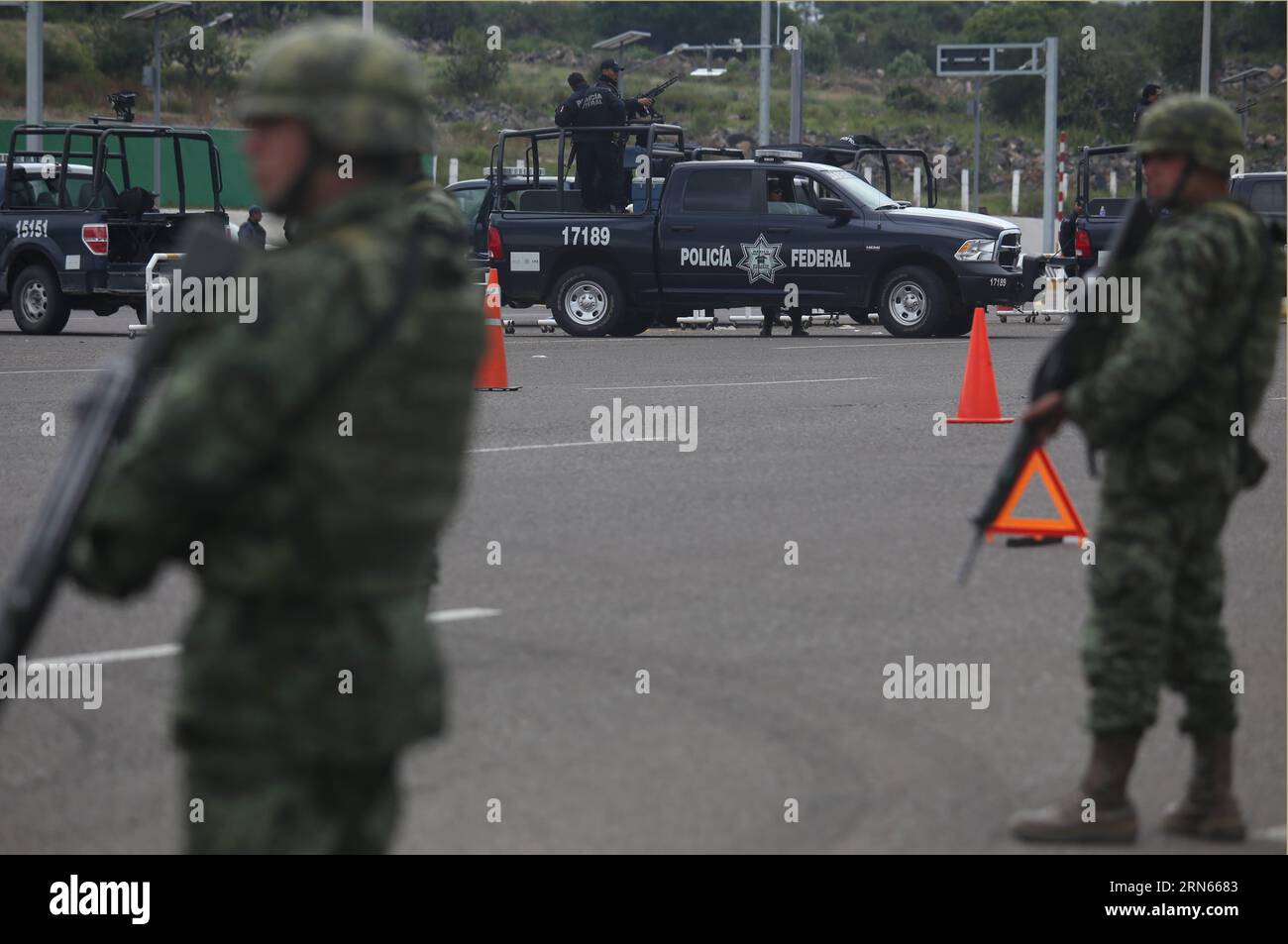 Des membres de la police fédérale et de la garde de l'armée mexicaine dans les environs du poste de péage Contepec de la route de l'Ouest à Michoacan, Mexique, le 12 juillet 2015. Joaquin El Chapo Guzman, le roi du cartel de la drogue mexicain, s'est évadé de prison par un tunnel de 1,5 km sous sa cellule, ont déclaré dimanche les autorités. Guzman, chef du cartel de la drogue de Sinaloa, a disparu samedi soir de la prison de haute sécurité Altiplano à l'extérieur de Mexico, selon la Commission de sécurité nationale. MEXIQUE-MICHOACAN-GUZMAN LOERA ArmandoxSolis PUBLICATIONxNOTxINxCHN membres de la police fédérale et de l'AR MEXICAINE Banque D'Images