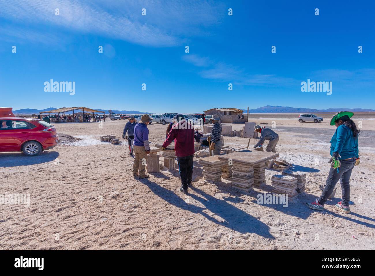 800 kilomètres carrés désert de sel Salinas grandes, les travailleurs construisent la table et le banc à partir de blocs de sel, touristes, voitures, restaurant, poêle à sel, montagnes, plaine, lithium Banque D'Images