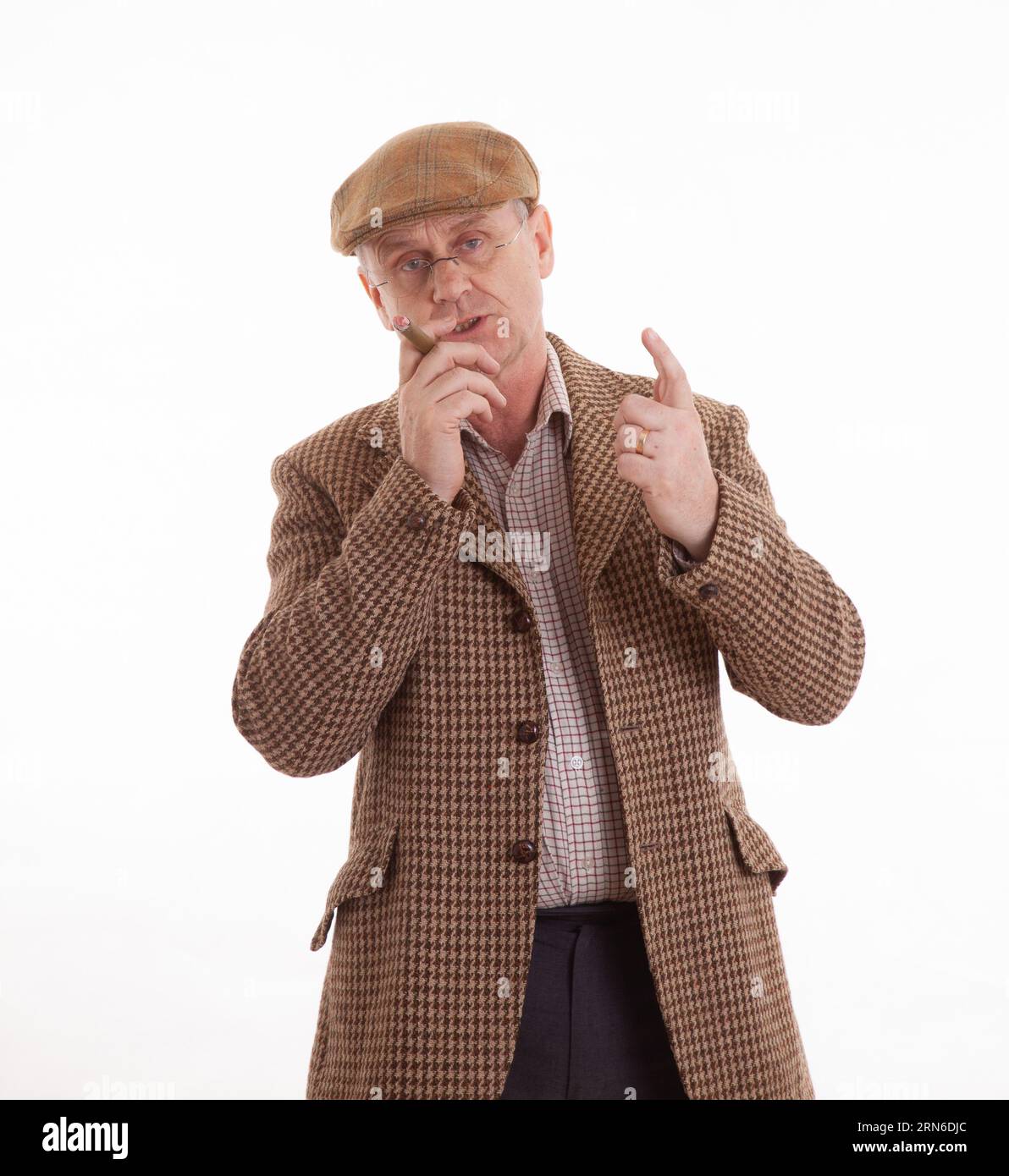 Un Anglais mature en tweeds classique fumant un grand cigare Banque D'Images