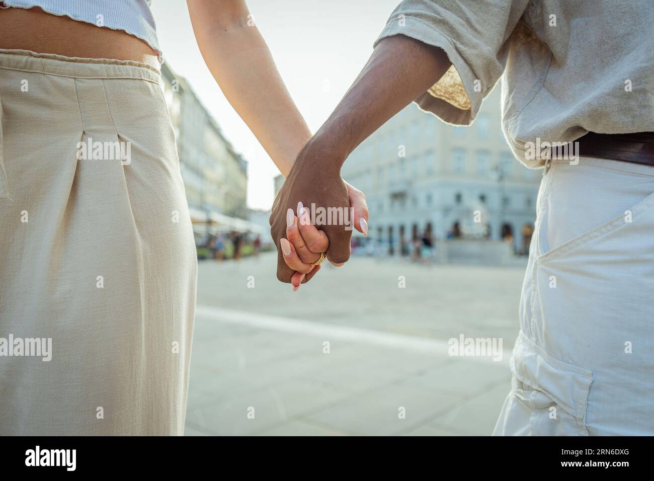 Gros plan des mains d'un couple multi-ethnique dans la ville pendant l'été Banque D'Images