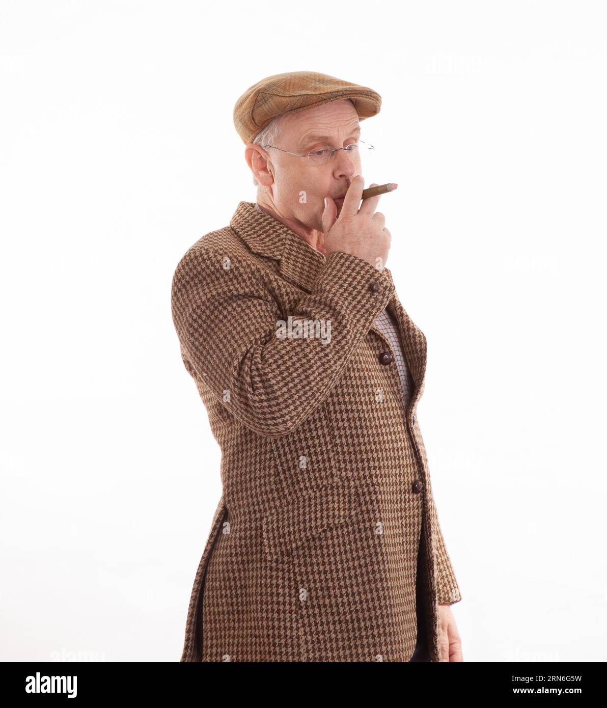Un Anglais mature en tweeds classique fumant un grand cigare Banque D'Images