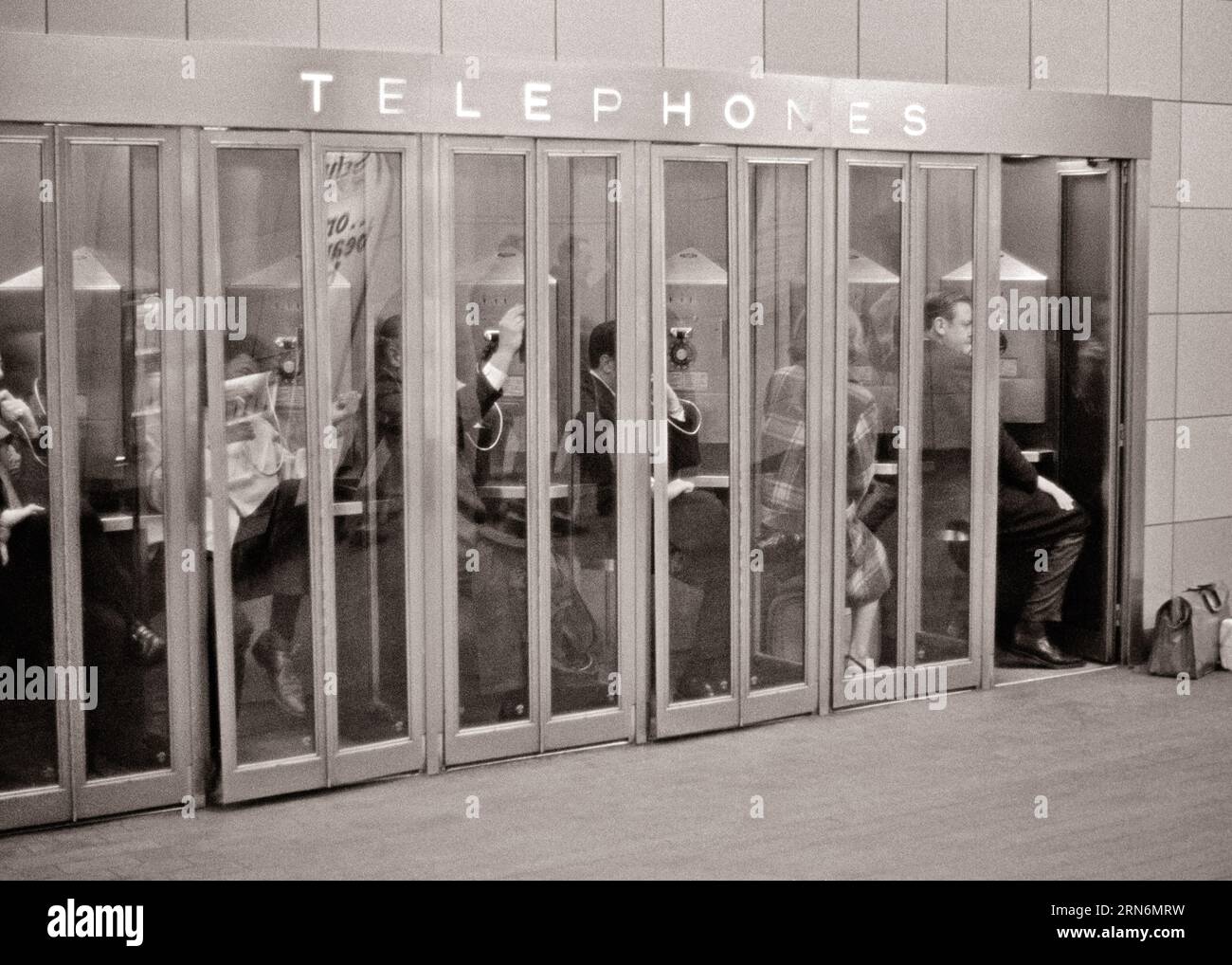 1960S 1970S GROUPE DE SIX CABINES TÉLÉPHONIQUES PUBLIQUES TÉLÉPHONES PAYANTS PLEINS DE NAVETTEURS ANONYMES GRAND CENTRAL STATION NYC NY USA - T6209 HAR001 HARS COPIE ESPACE DAMES PERSONNES ÉTATS-UNIS D'AMÉRIQUE HOMMES SIX NY B&W NAVETTEURS SERVICE À LA CLIENTÈLE PAYER PROGRÈS OPPORTUNITÉ NYC TÉLÉPHONES CONNEXION CONCEPTUELLE NEW YORK TÉLÉPHONES CABINES VILLES GRANDE GARE CENTRALE SOUTENIR NEW YORK VILLE PAYER ANONYME TÉLÉPHONES TÉLÉCOMMUNICATIONS NOIR ET BLANC ETHNICITÉ CAUCASIENNE COMMODITÉ HAR001 OLD FASHIONED Banque D'Images