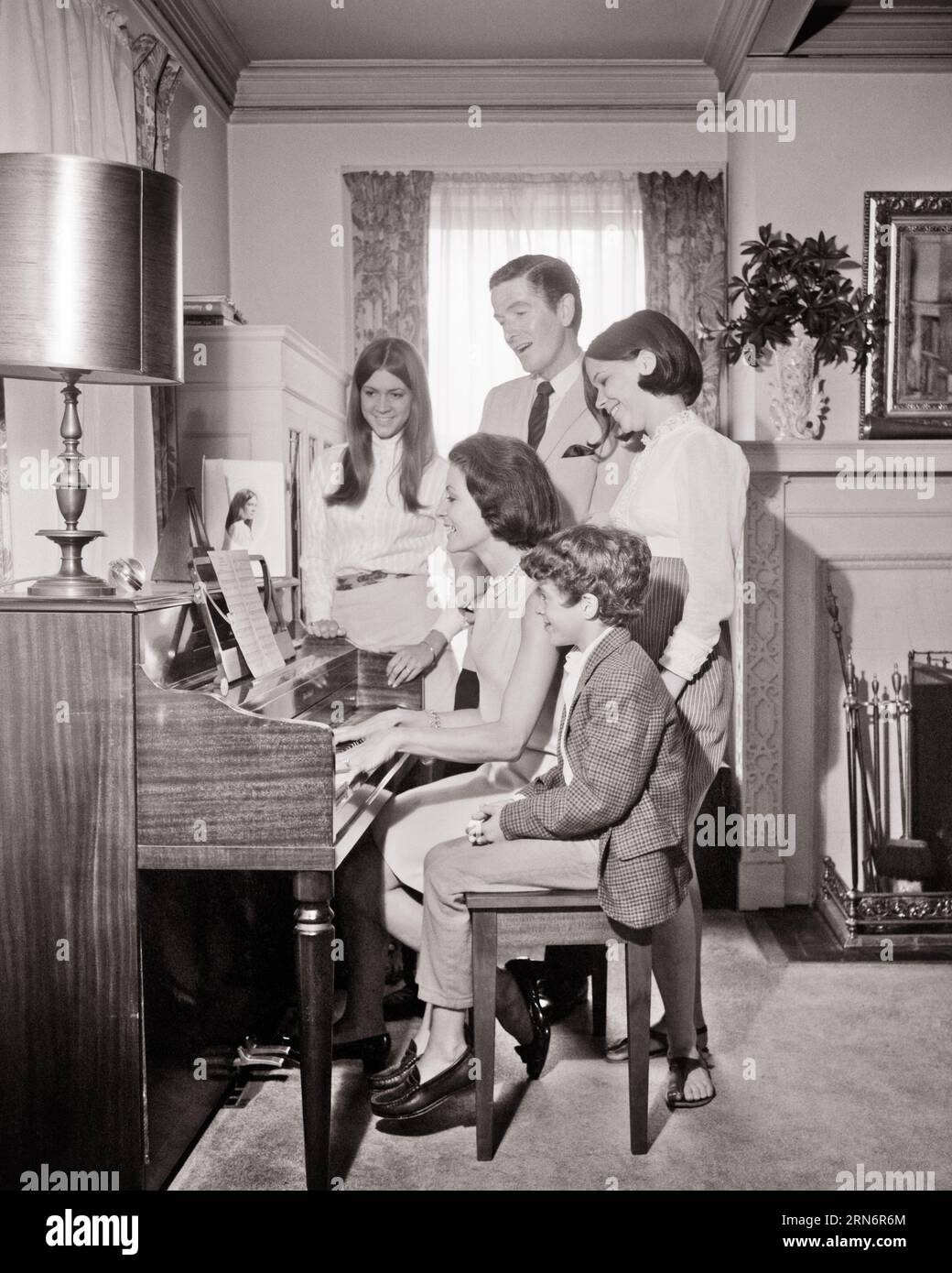 FAMILLE DES ANNÉES 1960 DE 5 CHANTANT AUTOUR DU SALON PIANO MÈRE JOUANT DU PIANO ET 3 ENFANTS ET DAD CHANTANT - M8991 HARS DAD MOM À L'INTÉRIEUR MUSICAL NOSTALGIQUE AUTOUR DE PAIRE SUBURBAINES URBAINES VIEUX TEMPS OCCUPÉ NOSTALGIE FRÈRE VIEILLE MODE SŒUR CHANTEUSE DE COMMUNICATION JUVÉNILE JEUNE ADULTE CHANTEURS DE TRAVAIL D'ÉQUIPE FILS FAMILLES JOIE STYLE DE VIE MUSICIEN SONORE FEMMES MARIÉES 5 FRÈRES ÉPOUX ÉPOUX ÉPOUX ACCUEIL VIE COPIE ESPACE AMITIÉ DEMI-LONGUEUR DAMES FILLES PERSONNES INSPIRATION MÂLES ADOLESCENTE DIVERTISSEMENT FRÈRES SŒURS PÈRES B&W PARTENAIRE ACTIVITÉ BONHEUR BIEN-ÊTRE LOISIRS ET CHANSON D'EXCITATION DADS Banque D'Images