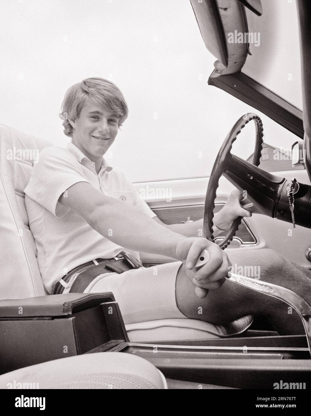 GARÇON ADOLESCENT SOURIANT DES ANNÉES 1970 CONDUISANT UNE VOITURE DÉCAPOTABLE AVEC TRANSMISSION MANUELLE REGARDANT LA CAMÉRA - M8648 HAR001 HARS HOMMES RISQUE ADOLESCENT CONFIANCE TRANSPORT B&W CONTACT VISUEL LIBERTÉ RÊVES BONHEUR AVENTURE JOYEUSE MANUEL VOITURES SPORTIVES EXCITATION ANGLE BAS FIERTÉ PUISSANTE SOURIRES TRANSMISSION AUTOMOBILES ÉCHAPPENT JOYEUSES VOITURES ADOLESCENTS FORD MUSTANG JUVÉNILES JEUNE FEMME ADULTE NOIR ET BLANC ETHNICITÉ CAUCASIENNE HAR001 VIEUX FAÇONNÉ Banque D'Images