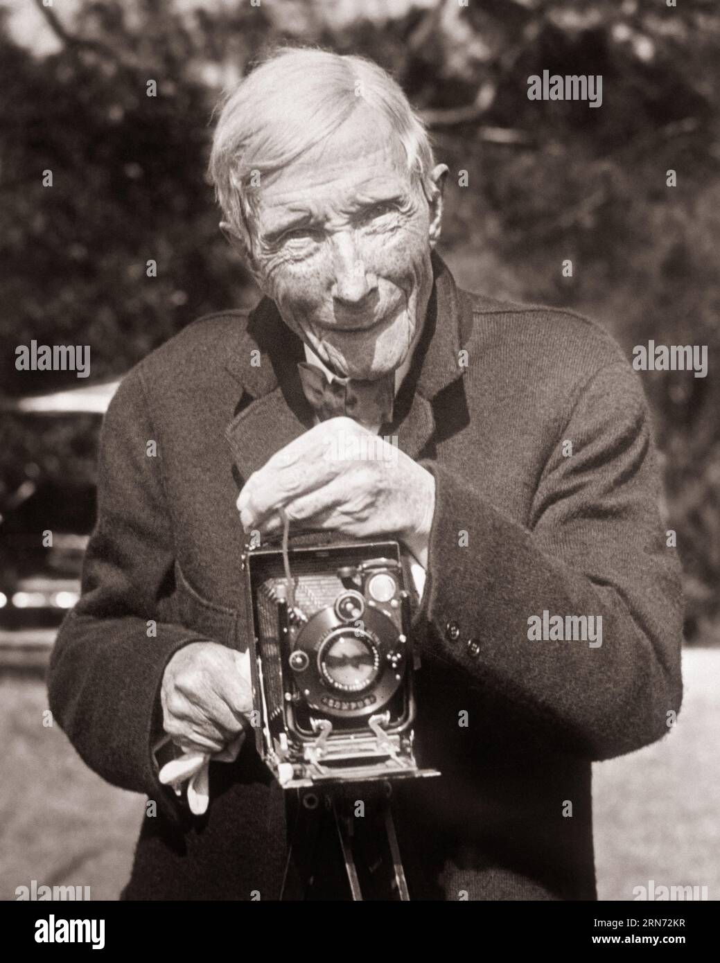 ANNÉES 1920 L'AÎNÉ JOHN D ROCKEFELLER PRENANT UNE PHOTO AVEC UN APPAREIL PHOTO À SOUFFLET PLIANT - Q73298 CPC001 HARS COPIE ESPACE DEMI-LONGUEUR PERSONNES INSPIRATION ÉTATS-UNIS D'AMÉRIQUE MÂLES SE PLIANT CONFIANCE B&W AMÉRIQUE DU NORD CONTACT VISUEL SUCCÈS AMÉRIQUE DU NORD VIEILLESSE OLDSTERS OLDSTER STRATÉGIE LEADERSHIP CÉLÈBRE PUISSANT PROGRÈS OPPORTUNITÉ OCCUPATIONS HAUT DE GAMME AÎNÉS AISÉS ROCKEFELLER HOMME ÂGÉ LE PLUS RICHE D BIEN À FAIRE SOUFFLETS NOIR ET LE MAGNAT DE L'ETHNICITÉ BLANCHE CAUCASIENNE, PHILANTHROPE À L'ANCIENNE Banque D'Images