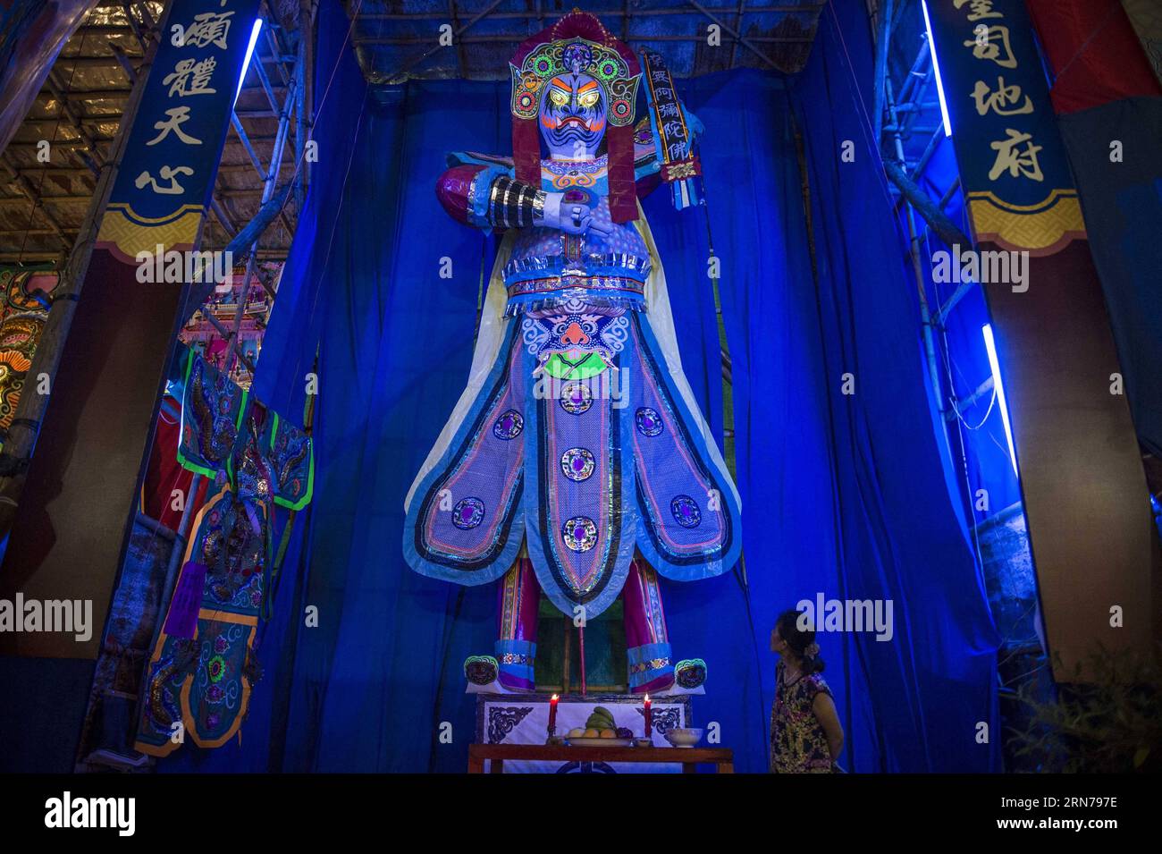 (150827) -- Hong Kong, Une femme regarde une sculpture de roi fantôme, ce qui est considéré comme l'une des incarnations de Bodhisattva Guanyin (Déesse de la Miséricorde), le chef de file des fantômes et des esprits errants à la veille du Festival des fantômes, à Kwun Tong dans le sud de la Chine à Hong Kong, le 26 août 2015. Dans la culture chinoise, le 15e jour du septième mois du calendrier lunaire est appelé jour des fantômes ou Festival des fantômes et le septième mois est considéré comme le mois des fantômes. Dans le bouddhisme, le jour des fantômes est aussi appelé Ullambana (Yu LAN ou Yu LAN Pen en pinyin). À Hong Kong, la coutume sur Ullambana a été introduite par Banque D'Images