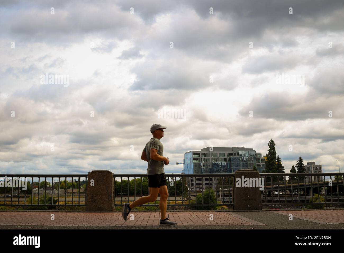 Homme courant le long de la rivière Willamette dans Tom McCall Waterfront Park dans le centre-ville de Portland, Oregon Banque D'Images