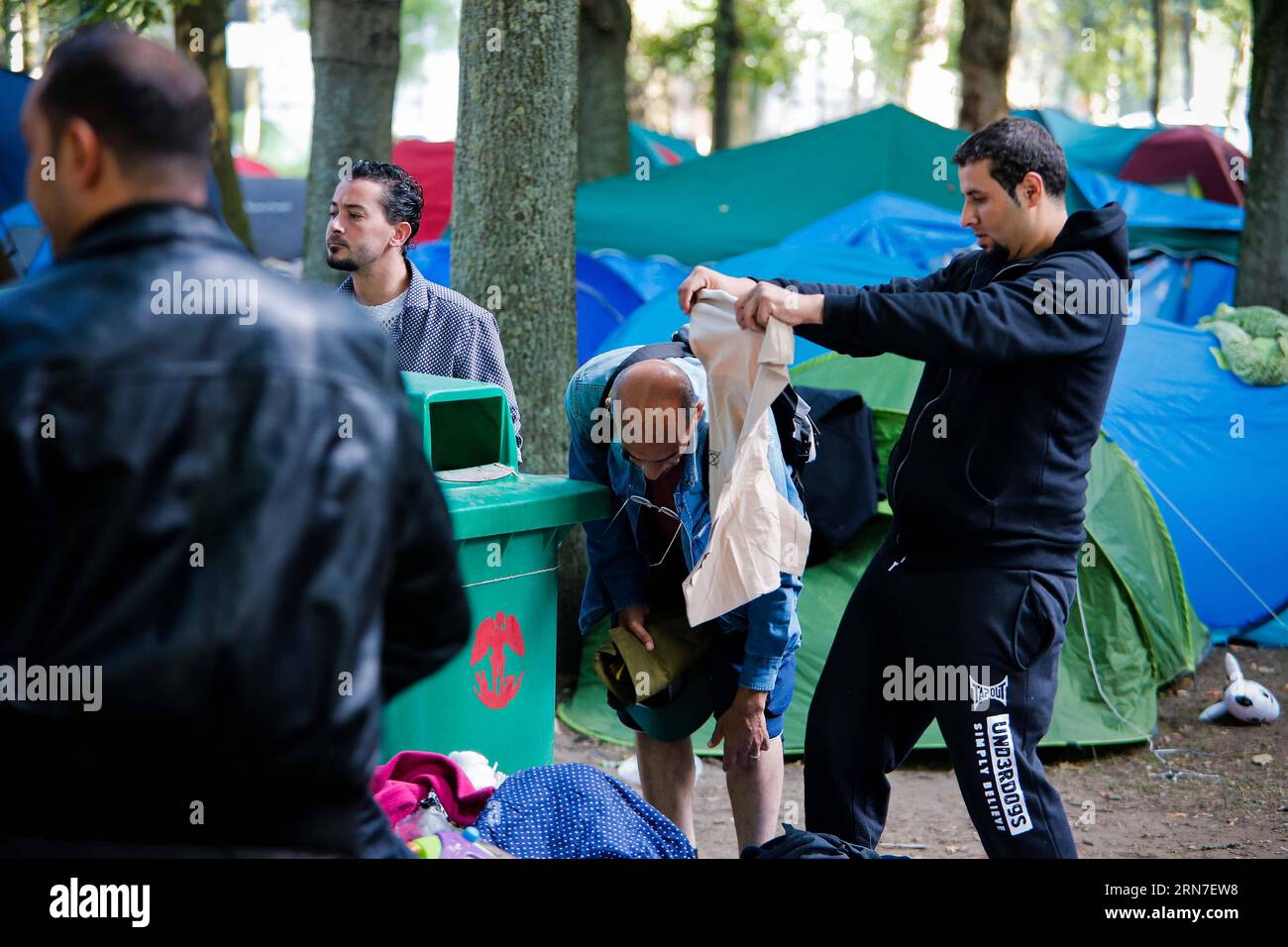 (150903) -- BRUXELLES, 3 septembre 2015 -- les demandeurs d'asile ramassent les vêtements donnés par les habitants dans un camp de fortune à l'extérieur du centre d'accueil des migrants à Bruxelles, Belgique, le 3 septembre 2015. Le nombre de réfugiés et de migrants traversant la Méditerranée cette année dépasse désormais les 300 000, selon le HCR, Agence des Nations Unies pour les réfugiés. Zhou Lei) BELGIQUE-EUROPE-MIGRANTS-DEMANDEURS D'ASILE ?? PUBLICATIONxNOTxINxCHN 150903 Bruxelles sept 3 2015 les demandeurs d'asile collectent les vêtements donnés par les habitants DANS un camp de fortune à l'extérieur du Centre d'accueil des immigrants à Bruxelles Belgique LE 3 2015 septembre le nombre de réfugiés et Banque D'Images