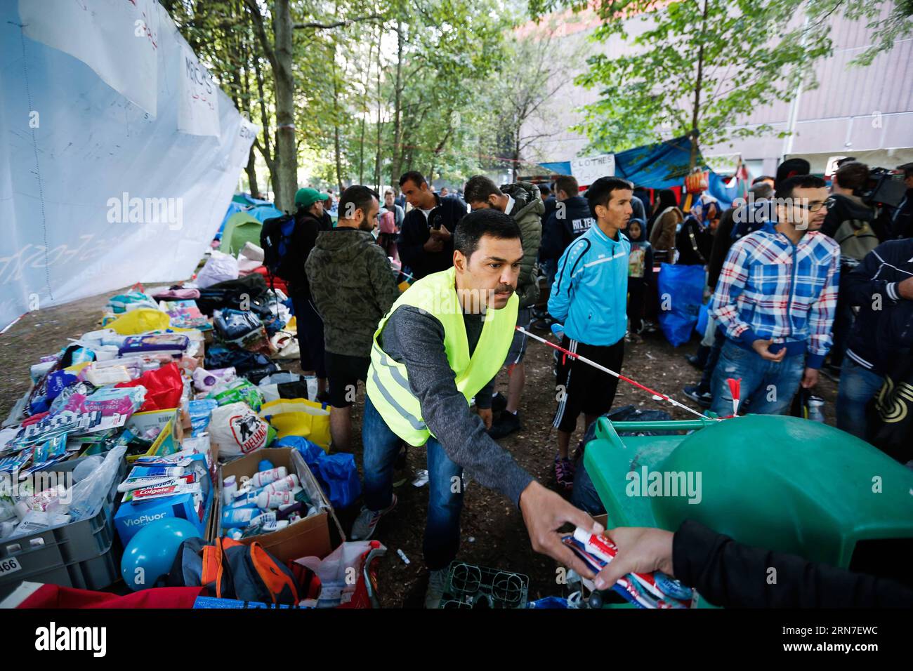 (150903) -- BRUXELLES, 3 septembre 2015 -- Un homme distribue des articles de vie à des demandeurs d'asile dans un camp de fortune à l'extérieur du centre d'accueil des migrants à Bruxelles, Belgique, le 3 septembre 2015. Le nombre de réfugiés et de migrants traversant la Méditerranée cette année dépasse désormais les 300 000, selon le HCR, Agence des Nations Unies pour les réfugiés. Zhou Lei) BELGIQUE-EUROPE-MIGRANTS-DEMANDEURS D'ASILE ?? PUBLICATIONxNOTxINxCHN 150903 Bruxelles sept 3 2015 un homme distribue des articles vivants aux demandeurs d'asile DANS un camp de fortune à l'extérieur du Centre d'accueil pour immigrants à Bruxelles Belgique LE 3 2015 septembre le nombre de réfugiés a Banque D'Images
