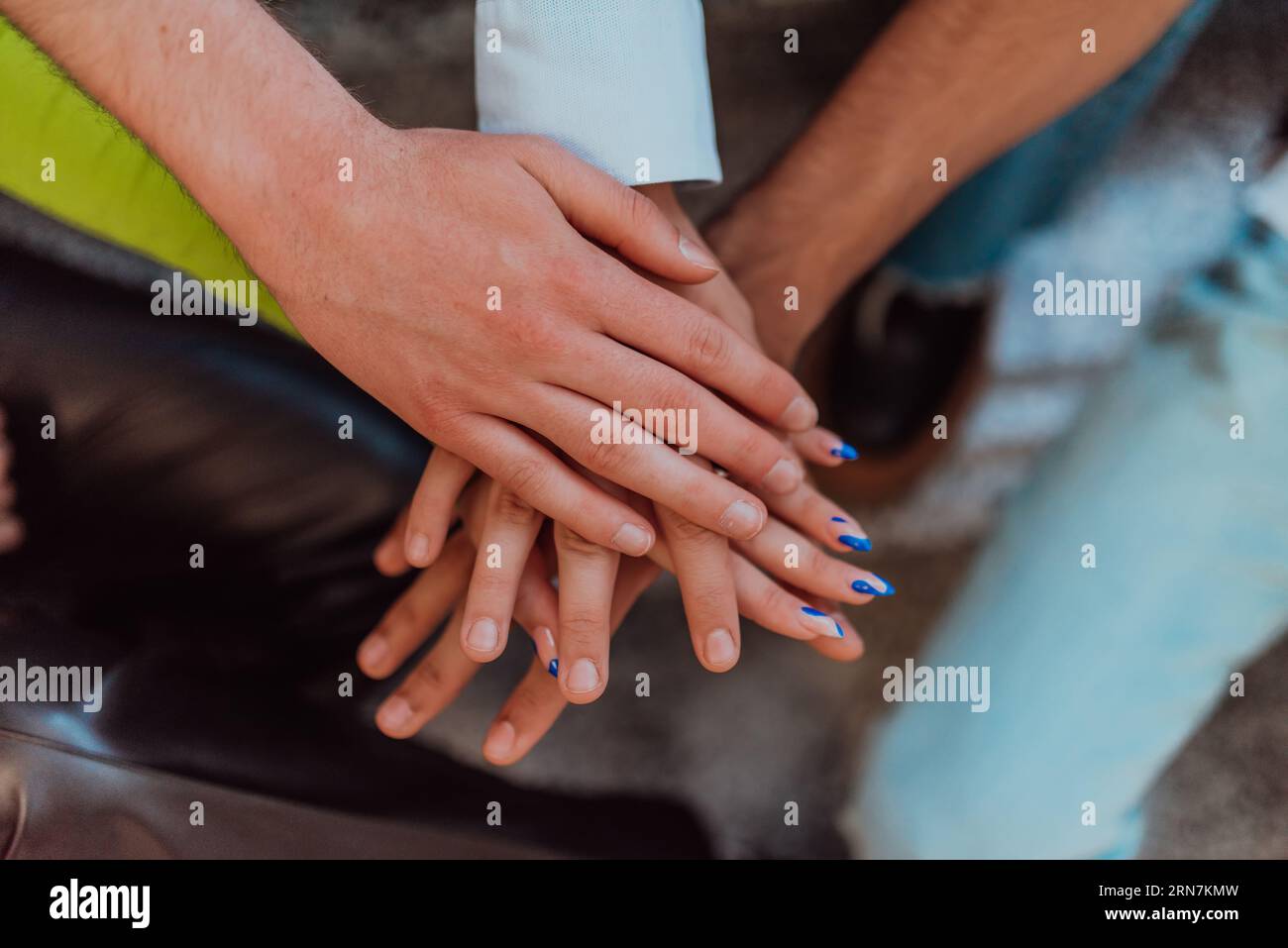 Un groupe diversifié d'étudiants symbolise l'unité alors qu'ils entrelacent leurs mains, dépeignant un sentiment de communauté, de collaboration et d'harmonie inclusive Banque D'Images