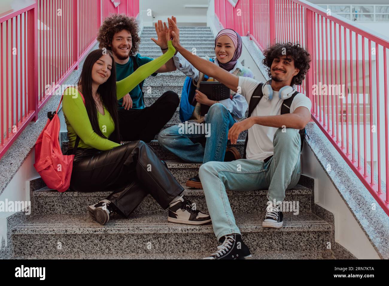 Un groupe diversifié d'étudiants symbolise l'unité alors qu'ils entrelacent leurs mains, dépeignant un sentiment de communauté, de collaboration et d'harmonie inclusive Banque D'Images