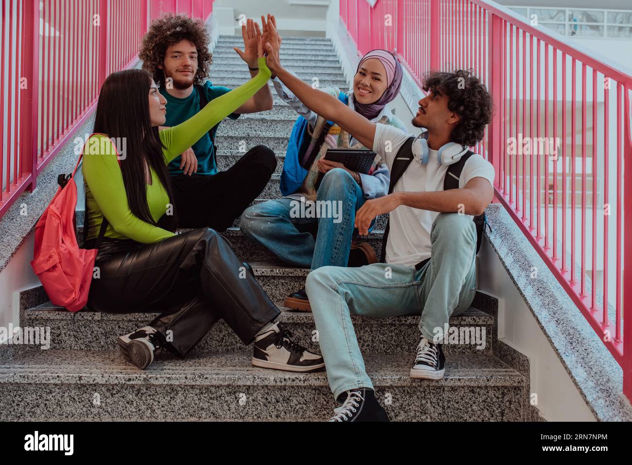 Un groupe diversifié d'étudiants symbolise l'unité alors qu'ils entrelacent leurs mains, dépeignant un sentiment de communauté, de collaboration et d'harmonie inclusive Banque D'Images