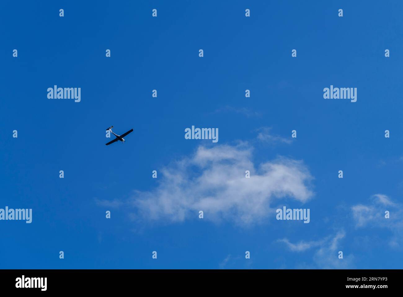 Petit avion blanc cessna monohélice volant dans un ciel bleu clair Banque D'Images