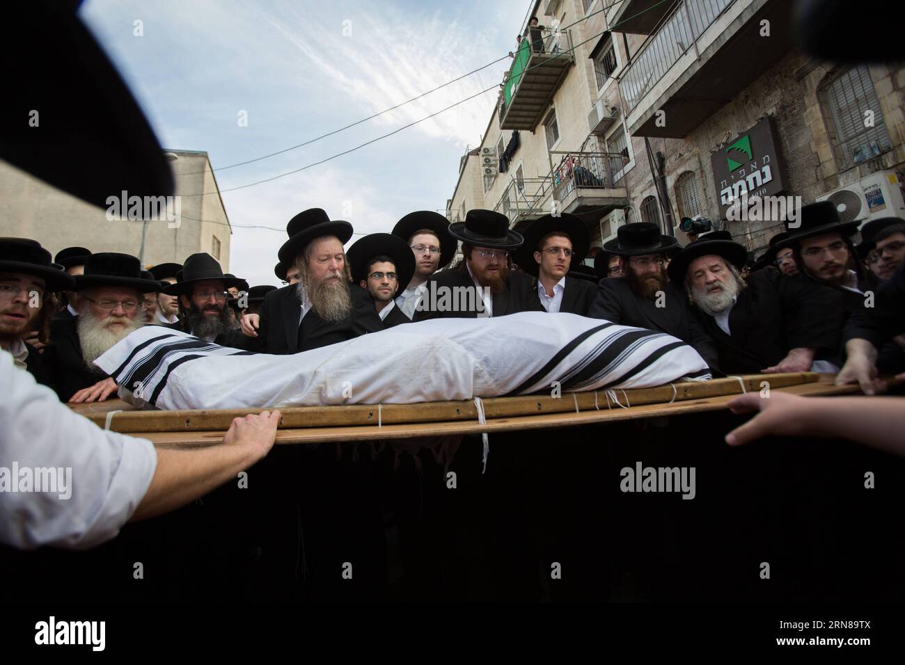 (151013) -- JÉRUSALEM, 13 octobre 2015 -- des juifs ultra-orthodoxes portent le corps du rabbin Yishayahu Karishevsky lors de ses funérailles dans le quartier de Mea Shearim, Jérusalem, le 13 octobre 2015. Un palestinien a percuté un véhicule portant le logo de la compagnie nationale de télécommunications, Bezeq, contre une foule de navetteurs qui attendaient à une gare routière dans un autre quartier de la ville. Il est ensuite sorti de son véhicule, poignardant des gens, avant d'être abattu, a déclaré la porte-parole de la police Luba Samri. Yishayahu Karishevsky, un israélien d'une soixantaine d'années, a été déclaré mort par les ambulanciers paramédicaux sur les lieux, et trois autres p Banque D'Images
