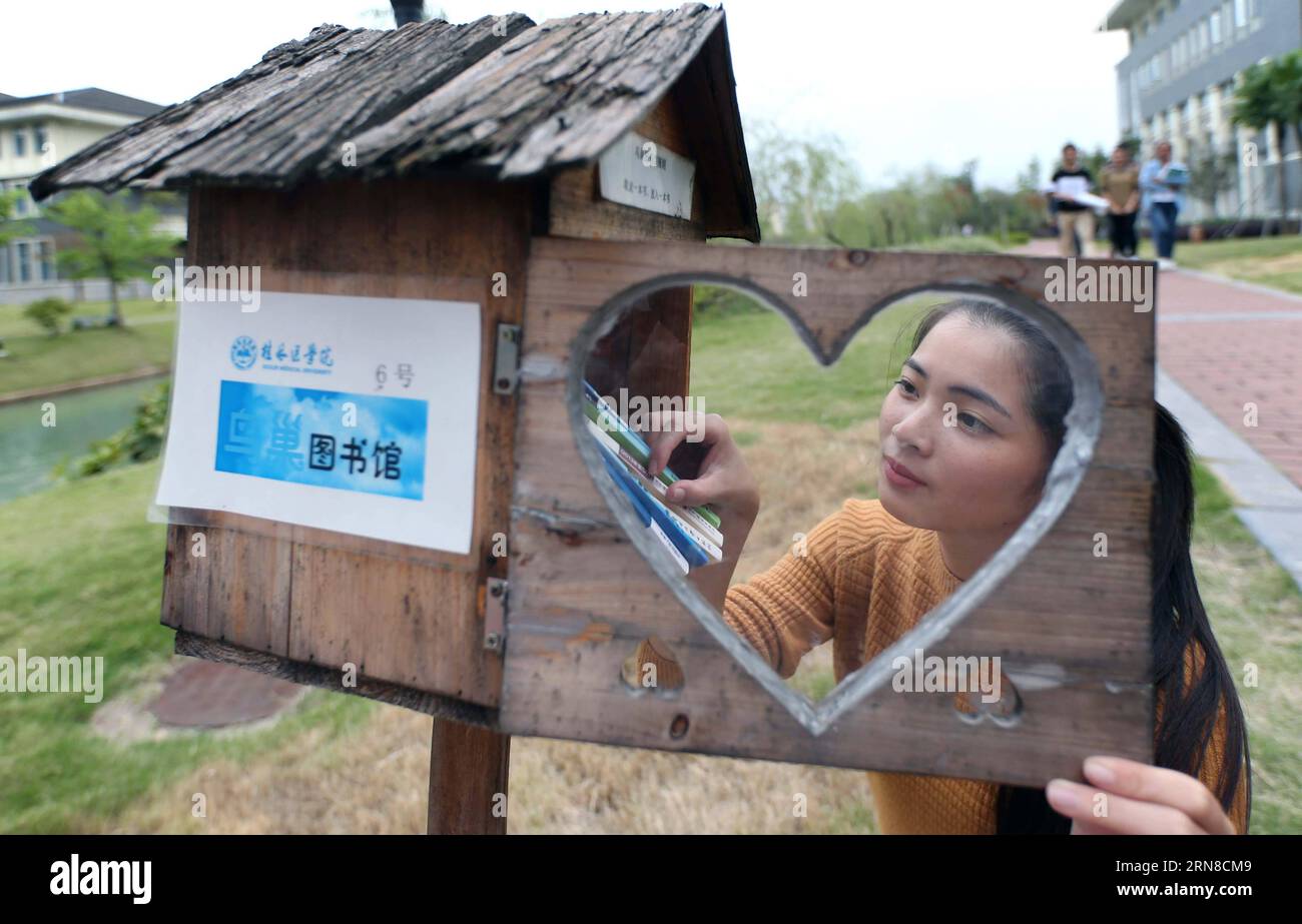 (151017) -- GUILIN, 17 octobre 2015 -- Un étudiant emprunte des livres dans une bibliothèque en bois de nid d oiseau à l Université de médecine de Guilin, dans la région autonome de Guangxi Zhuang, dans le sud-ouest de la Chine, le 13 octobre 2015. Vingt bibliothèques gratuites avec motif de nid d oiseau ont été installées à l université depuis 2014. ) (MCG) CHINA-GUANGXI-GUILIN-BIRD S NEST LIBRARY (CN) LiuxJiaoqing PUBLICATIONxNOTxINxCHN Guilin OCT 17 2015 un étudiant emprunte des livres À une bibliothèque Wooden Bird S Nest Library À Guilin Medical University Southwest China S Guangxi Zhuang Autonomous Region OCT 13 2015 vingt bibliothèques gratuites avec Bird S Nest modèle Bird S Be Banque D'Images