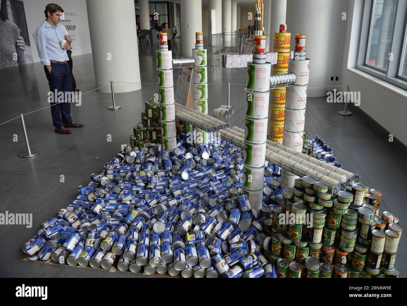 (151106) -- NEW YORK, 6 novembre 2015 -- Un homme regarde une sculpture faite de boîtes de conserve lors de la 22e exposition Canconstruction à New York, le 6 novembre 2015. Les œuvres des lauréats du 22e Concours international de design Canconstruction sont exposées au Brookfield place dans le centre-ville de Manhattan. L'exposition présente des sculptures entièrement faites de conserves non ouvertes. Plus de 1 200 lauréats locaux de 125 villes du monde entier ont participé à la compétition. La nourriture en conserve utilisée dans l’exposition sera donnée à une banque alimentaire locale responsable de nourrir plus d’un million d’Hungry New y Banque D'Images