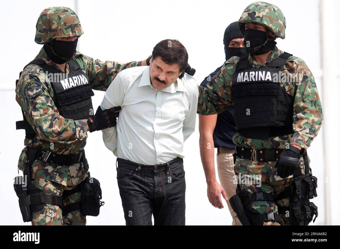 Drogenboss El Chapo Guzman à Mexiko gefasst -- MEXICO -- une photo prise le 22 février 2014 montre des membres de la marine mexicaine qui gardent Joaquin Guzman Loera (C), alias El Chapo , lors de sa présentation aux médias à Mexico, capitale du Mexique. Le fugitif roi de la drogue Joaquin El Chapo Guzman a été repris plusieurs mois après son évasion de prison, a déclaré le président Enrique Pena Nieto le 8 janvier 2016. (fnc) MEXICO-MEXICO CITY-GUZMAN LOERA-RECAPTURE DavidxdexlaxPaz PUBLICATIONxNOTxINxCHN Banque D'Images