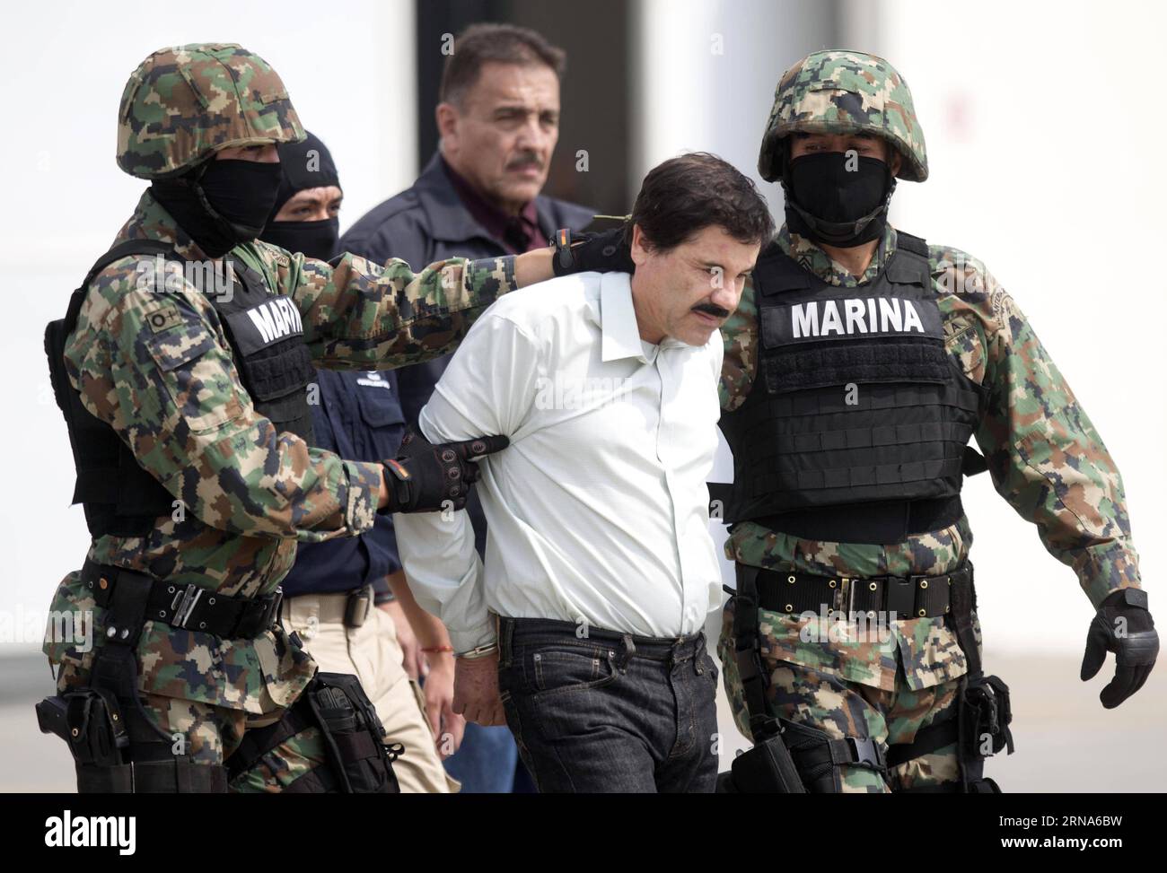 Drogenboss El Chapo Guzman à Mexiko gefasst -- MEXICO -- photo prise le 22 février 2014 montre des membres de la Marine mexicaine qui gardent Joaquin Guzman Loera (C, front), alias El Chapo , lors de sa présentation aux médias à Mexico, capitale du Mexique. Le fugitif roi de la drogue Joaquin El Chapo Guzman a été repris plusieurs mois après son évasion de prison, a déclaré le président Enrique Pena Nieto le 8 janvier 2016. (fnc) MEXICO-MEXICO CITY-GUZMAN LOERA-RECAPTURE DavidxdexlaxPaz PUBLICATIONxNOTxINxCHN Banque D'Images