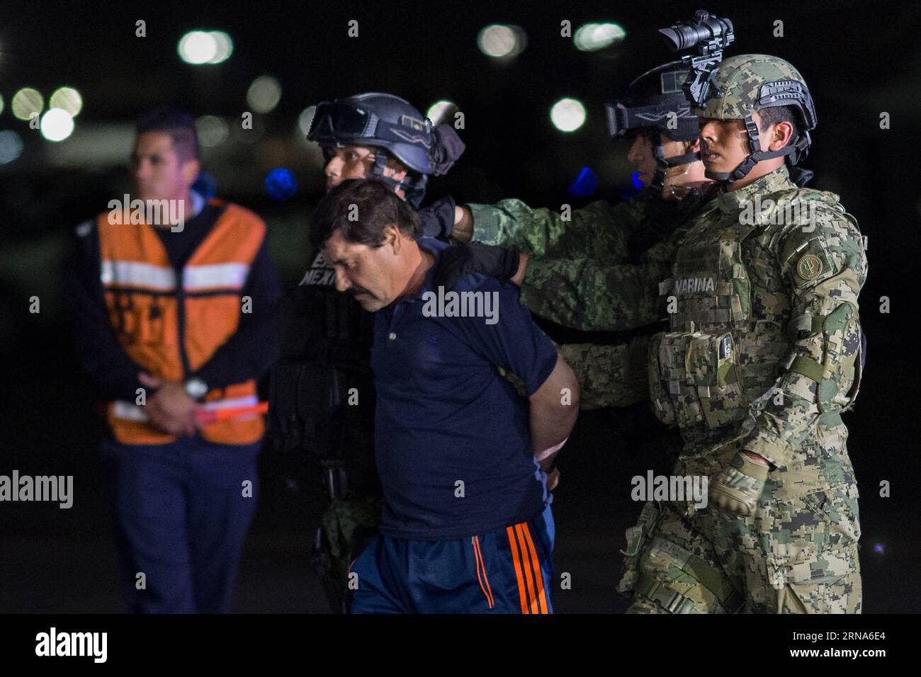 (160109) -- MEXICO, 8 janvier 2016 -- des soldats escortent Joaquin Guzman Loera, alias El Chapo , à son arrivée au hangar du bureau du procureur général, à Mexico, capitale du Mexique, le 8 janvier 2016. Après un raid tôt le matin dans la ville de Los Mochis, dans l État du Sinaloa, dans le nord-ouest du Mexique, par la police et les marines mexicaines vendredi, le chef du cartel du Sinaloa, Joaquin Guzman Loera, a été repris, six mois après sa deuxième évasion de prison. MEXICO-MEXICO CITY-SECURITY-GUZMAN LOERA-RECAPTURE PedroxMera PUBLICATIONxNOTxINxCHN 160109 Mexico Jan 8 2016 soldats escorte Joaquin Guzman Loera A. Banque D'Images