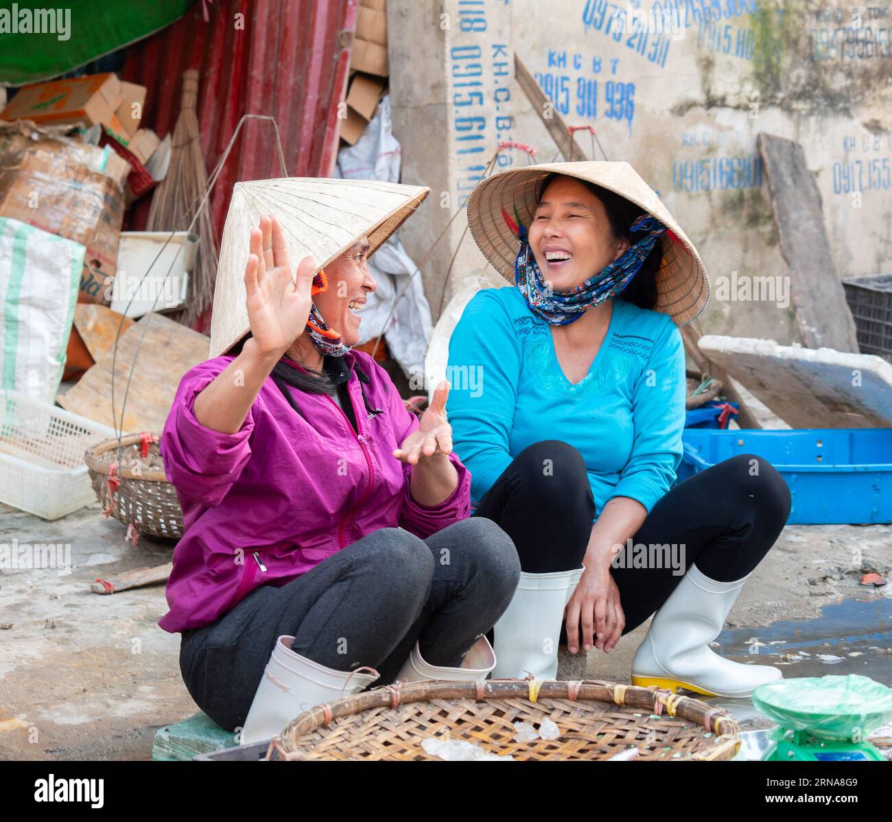 Deux vendeuses de rue discutant à Hai Thanh, un village de pêcheurs le long de la rivière Song Lach Bang dans la province de Thanh Hoa au Vietnam. Banque D'Images