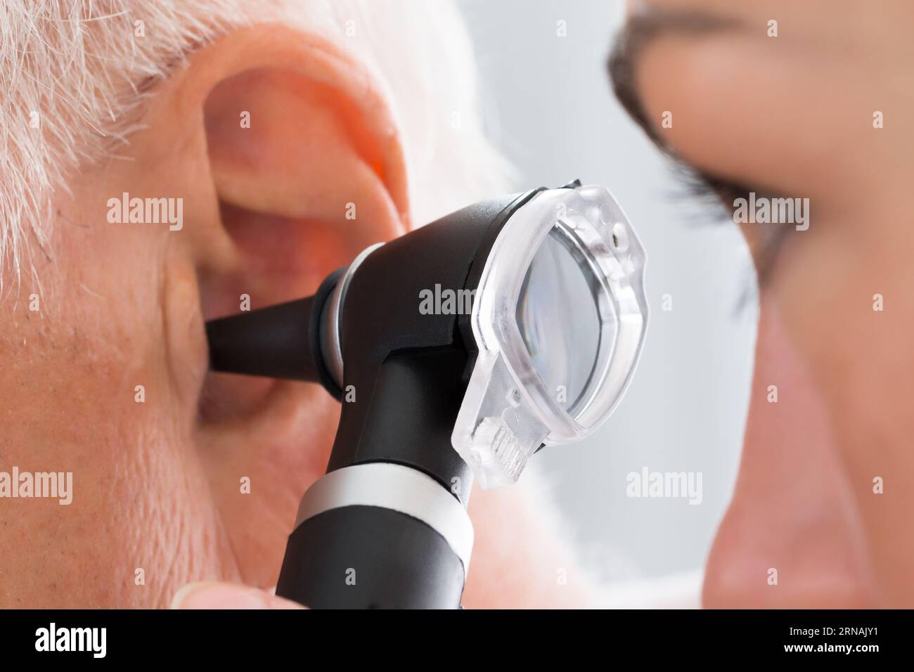 Close-up of Female Doctor Examining Patient's Ear avec Otoscope Banque D'Images