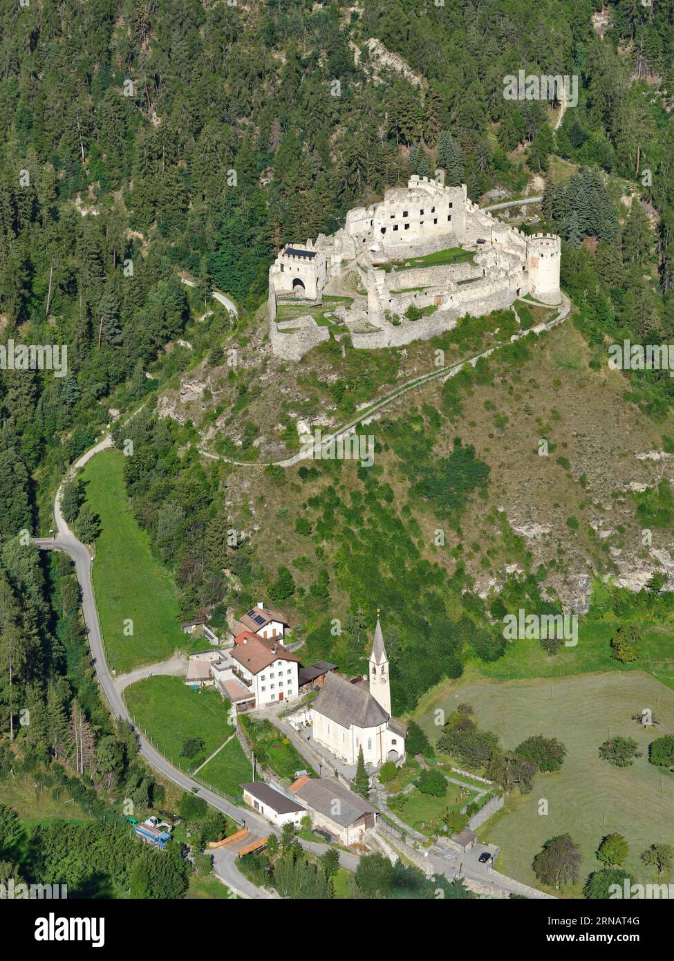 VUE AÉRIENNE. Castello di Montechiaro (en italien) ou Schloss Lichtenberg (en allemand) surplombant une église paroissiale. Trentin-Haut-Adige, Italie. Banque D'Images