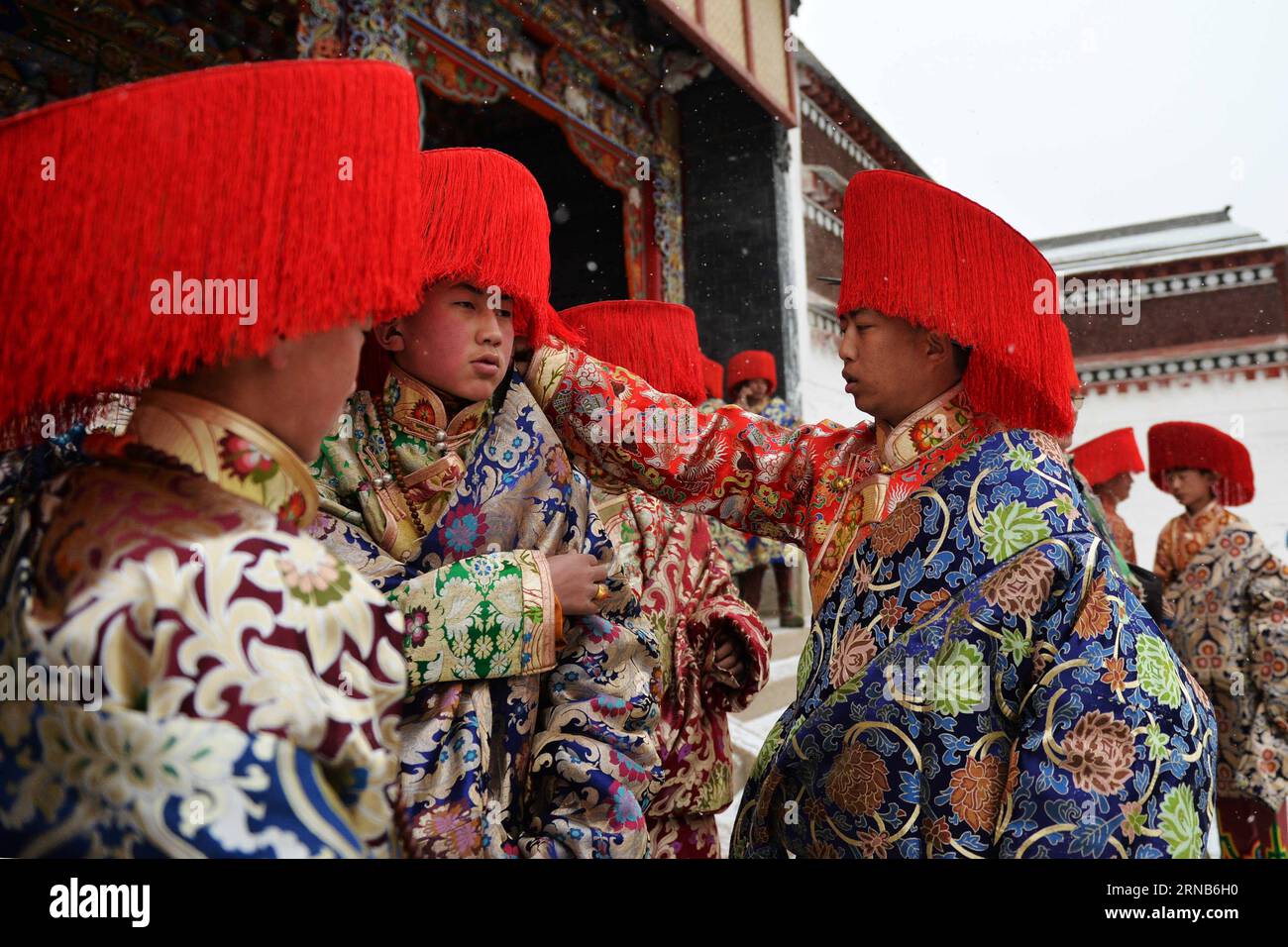 (160221) -- XIAHE, 21 février 2016 -- Un jeune homme du groupe ethnique tibétain ajuste ses vêtements pour un partenaire avant une représentation de danse religieuse au monastère de Labrang dans le comté de Xiahe, province du Gansu, au nord-ouest de la Chine, le 21 février 2016. Le monastère de Labrang est l'un des six temples prestigieux de la secte Gelug du bouddhisme tibétain. Le spectacle de danse racontant des histoires religieuses a attiré des milliers de personnes du pays et de l'étranger. )(MCG) CHINA-GANSU-XIAHE-LABRANG MONASTÈRE-DANSE RELIGIEUSE (CN) ChenxBin PUBLICATIONxNOTxINxCHN Xiahe février 21 2016 un jeune homme du groupe ethnique tibétain AJUSTE DES vêtements pour un partenaire BE Banque D'Images