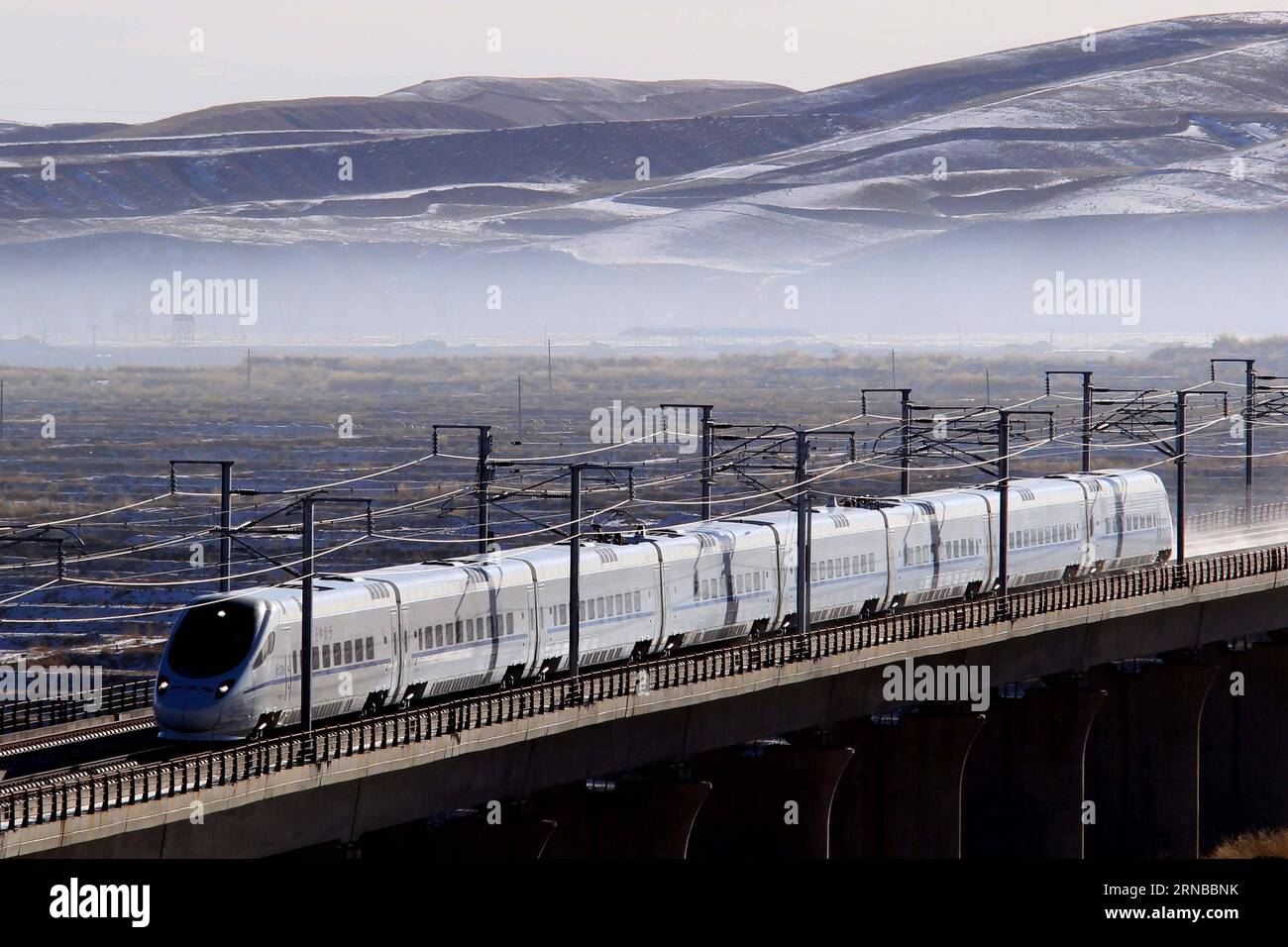 La photo prise le 13 décembre 2014 montre un train à grande vitesse circulant sur la section Zhangye de la ligne ferroviaire à grande vitesse Lanzhou-Xinjiang, dans la province du Gansu du nord-ouest de la Chine. La construction de plus de chemins de fer à grande vitesse a été un sujet brûlant lors des sessions annuelles des législatures provinciales et des organes consultatifs politiques de la Chine qui se sont tenues intensivement en janvier. La Chine possède le plus grand réseau ferroviaire à grande vitesse au monde, avec une longueur totale d exploitation atteignant 19 000 km à la fin de 2015, soit environ 60 pour cent du total mondial. Le réseau ferroviaire à grande vitesse en expansion offre un confort et une commodité sans précédent aux voyageurs Banque D'Images