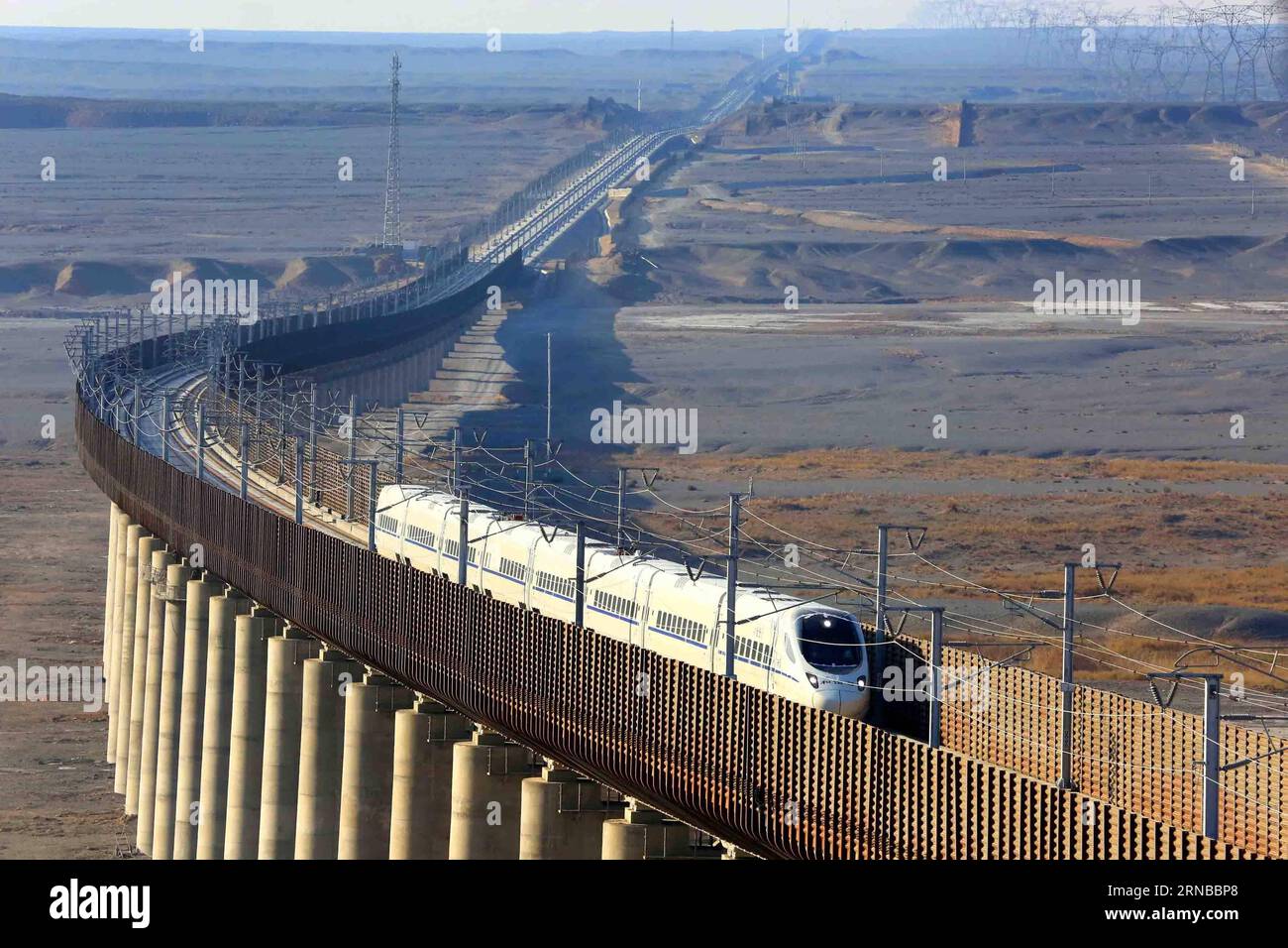 La photo prise le 15 novembre 2014 montre un train à grande vitesse circulant sur la ligne de chemin de fer à grande vitesse Lanzhou-Xinjiang, au nord-ouest de la Chine. La construction de plus de chemins de fer à grande vitesse a été un sujet brûlant lors des sessions annuelles des législatures provinciales et des organes consultatifs politiques de la Chine qui se sont tenues intensivement en janvier. La Chine possède le plus grand réseau ferroviaire à grande vitesse au monde, avec une longueur totale d exploitation atteignant 19 000 km à la fin de 2015, soit environ 60 pour cent du total mondial. Le réseau ferroviaire à grande vitesse en pleine expansion offre aux voyageurs un confort et une commodité sans précédent et stimule le développement local Banque D'Images