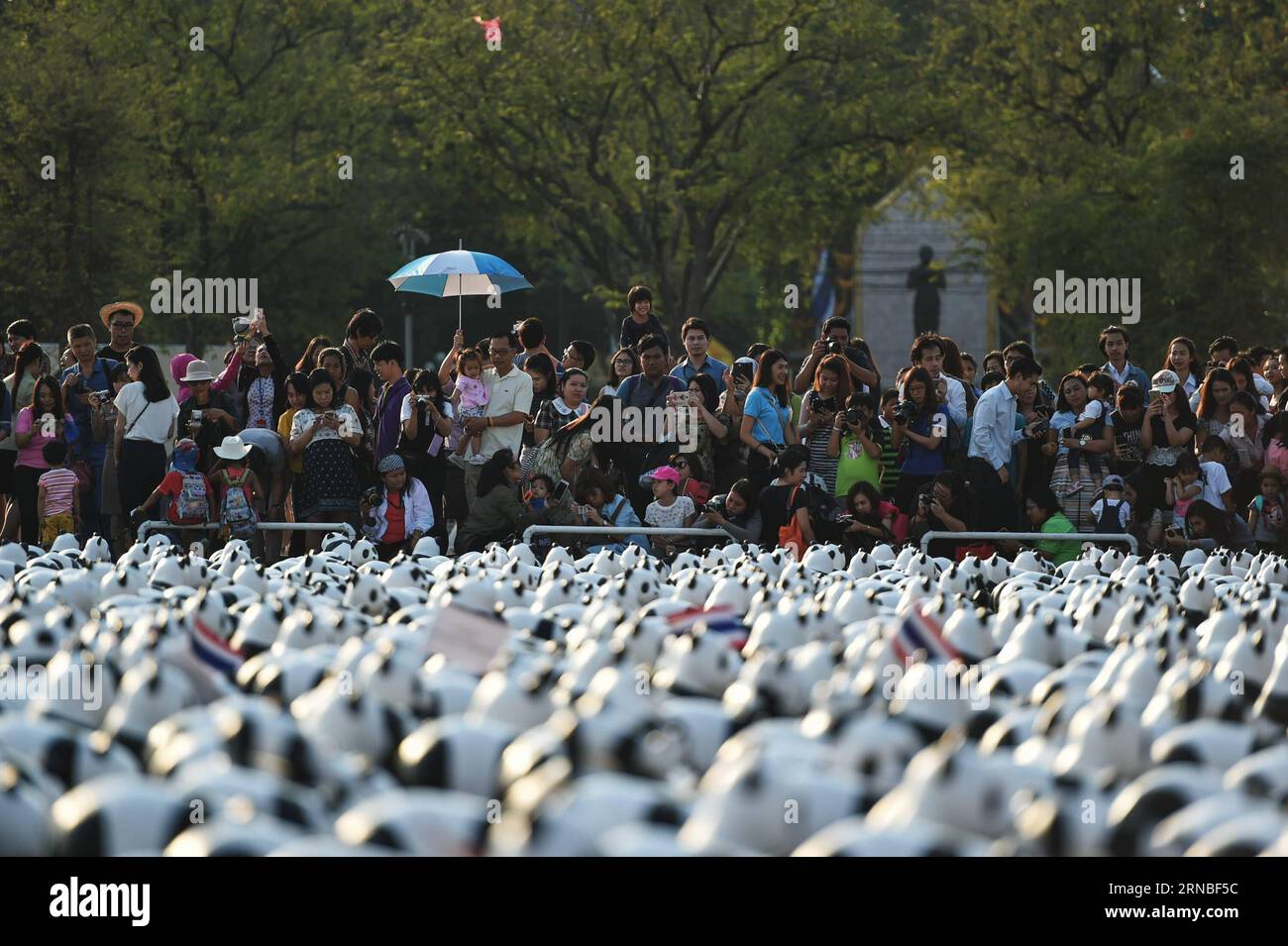 (160304) -- BANGKOK, 4 mars 2016 -- Un essaim de spectateurs regardent des pandas en papier-mache lors d'une exposition de l'œuvre d'art en papier-mache 1600 Pandas sur la place Sanam Luang à Bangkok, Thaïlande, le 4 mars 2016. 1600 Pandas , une œuvre d'art en papier-mache créée en 2008 par l'artiste français Paulo Grangeon pour le Fonds mondial pour la nature (WWF), a commencé sa tournée d'exposition en Thaïlande vendredi lors d'un premier spectacle flash-mob sur la place Sanam Luang de Bangkok qui a duré trois heures. Les 1 600 pandas en papier seront présentés à neuf autres arrêts à Bangkok et Ayutthaya avant la fin de la visite de l'exposition le 10 avril. TH Banque D'Images