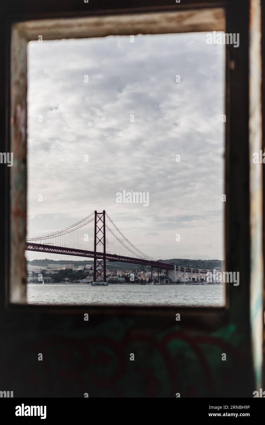 Une verticale d'un pont vue à travers une fenêtre par temps nuageux à Ponte, Portugal Banque D'Images