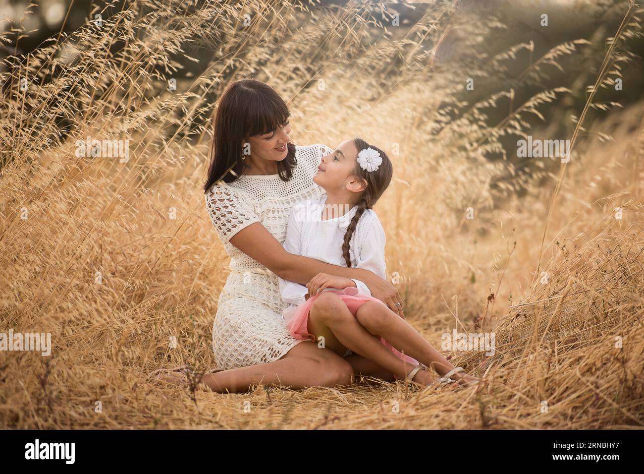 mère et fille assises sur le sol dans le champ en après-midi Banque D'Images