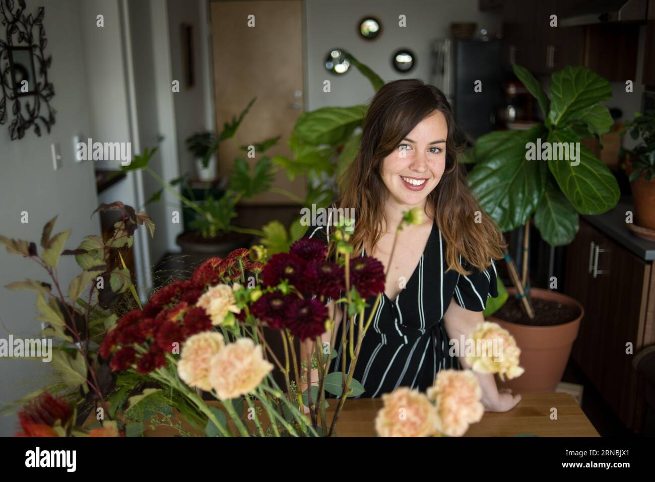 Femme souriant à la caméra avec des fleurs Banque D'Images