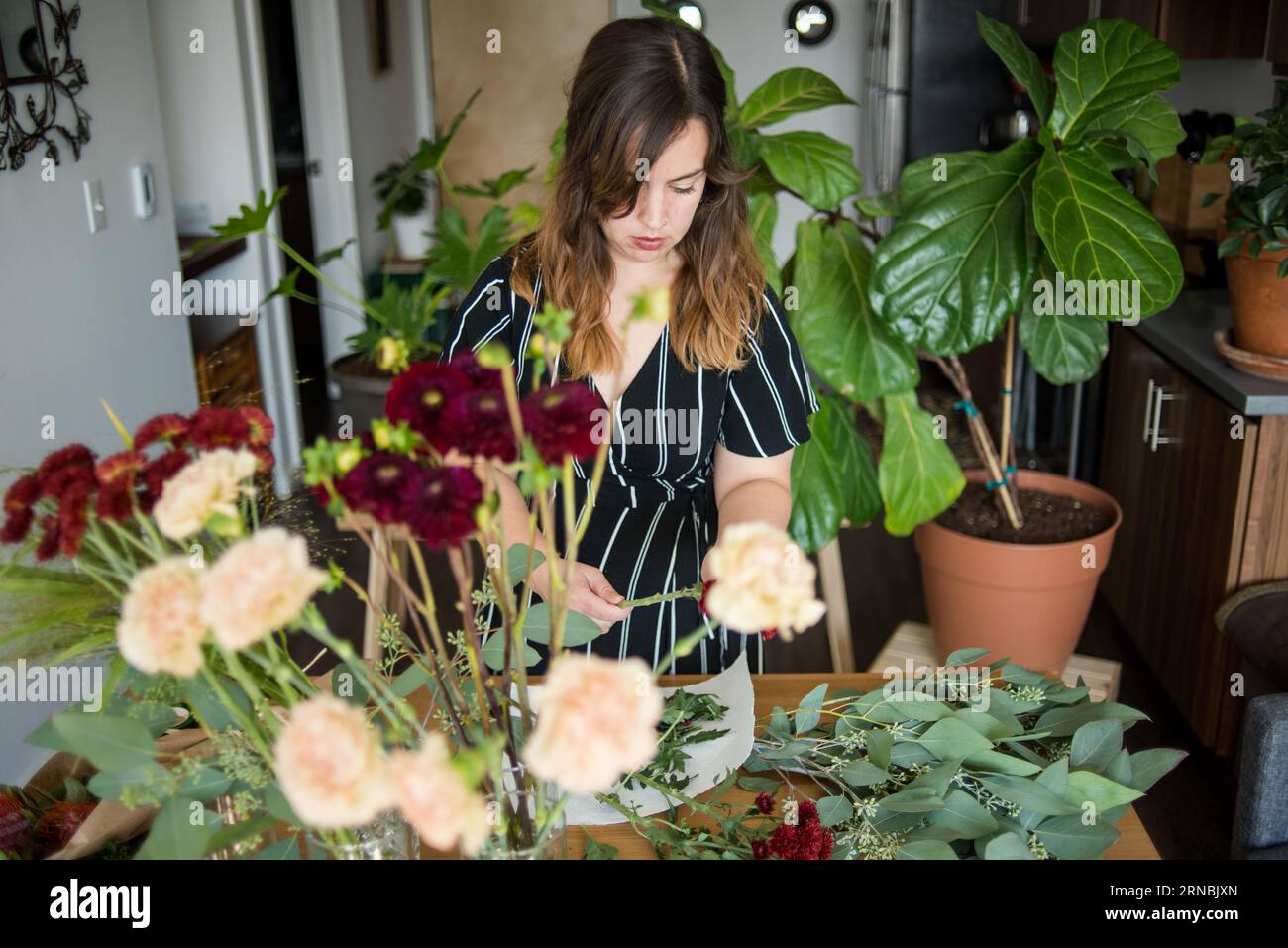 Femme assemblant bouquet de fleurs Banque D'Images